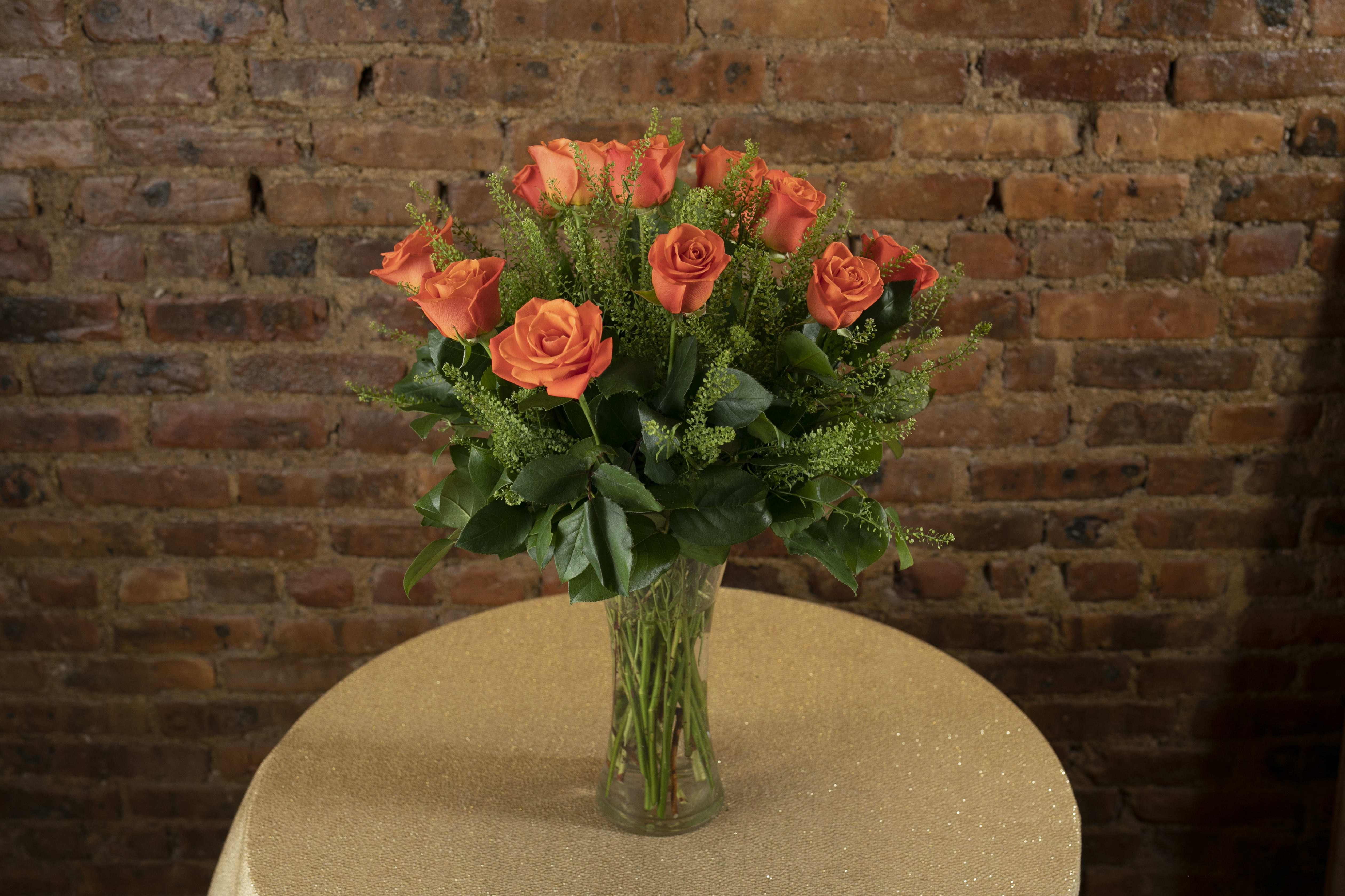 Orange roses arranged in a clear glass vase