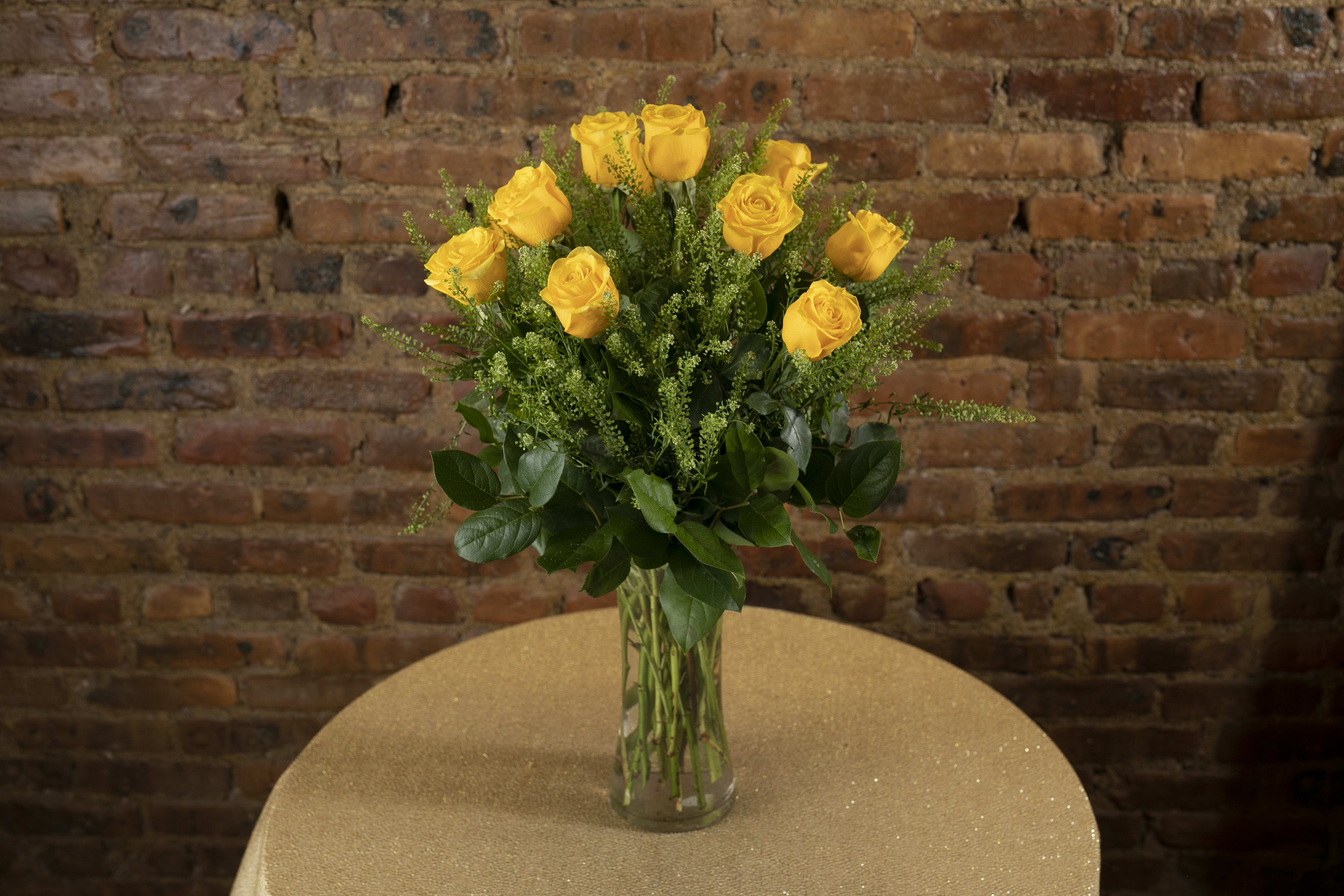 Yellow roses arranged in a clear glass vase