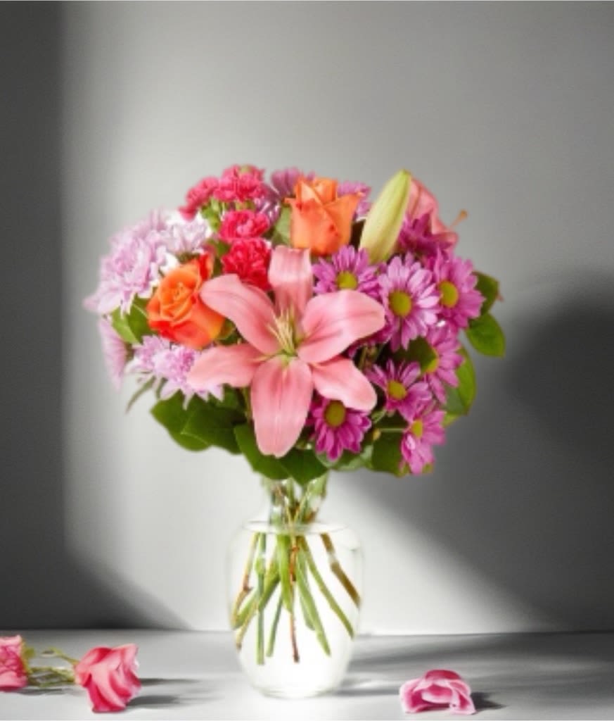 Pink and orange mixed bouquet in a clear glass vase