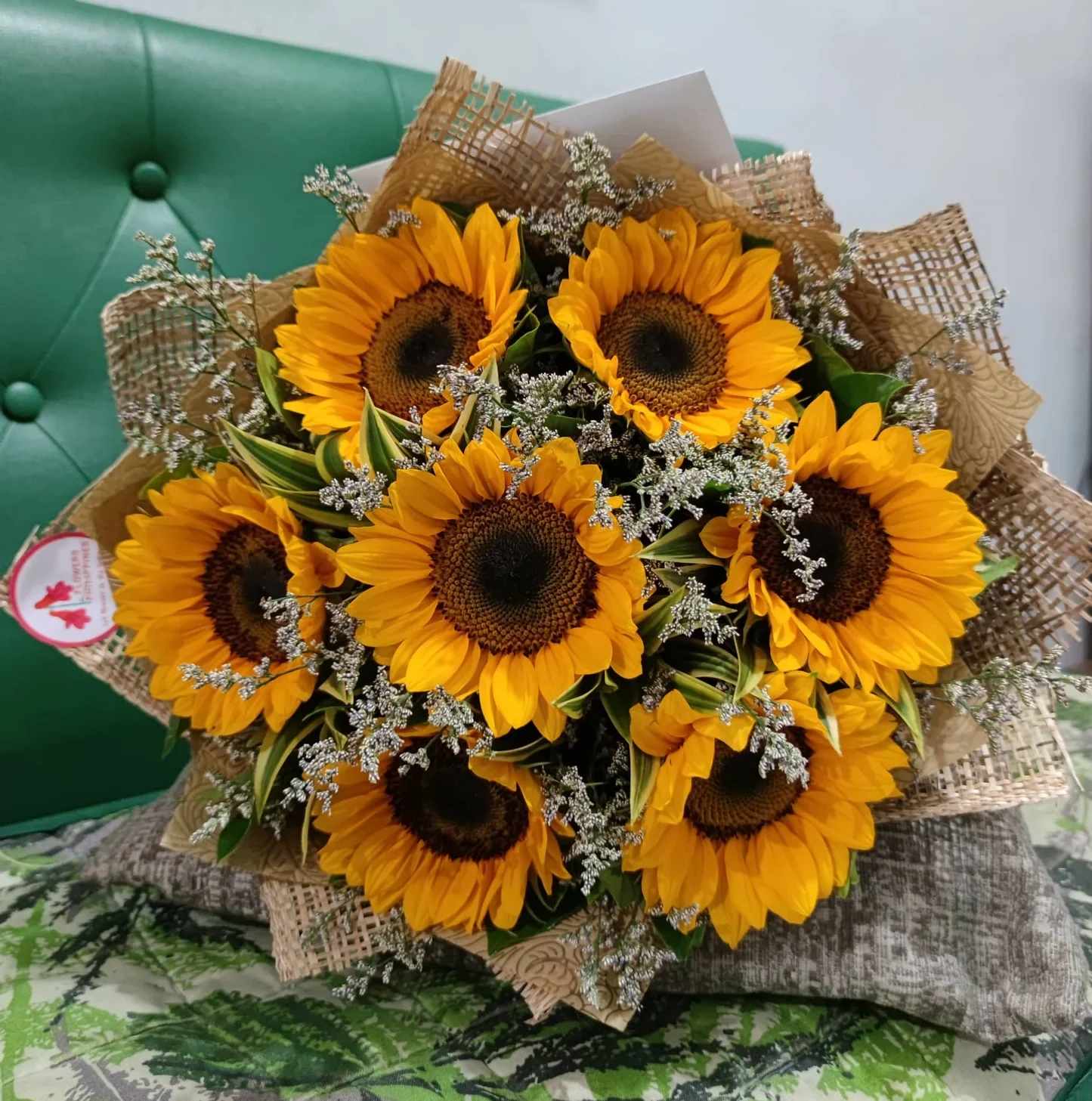 Bouquet of sunflowers with small white filler flowers wrapped in burlap