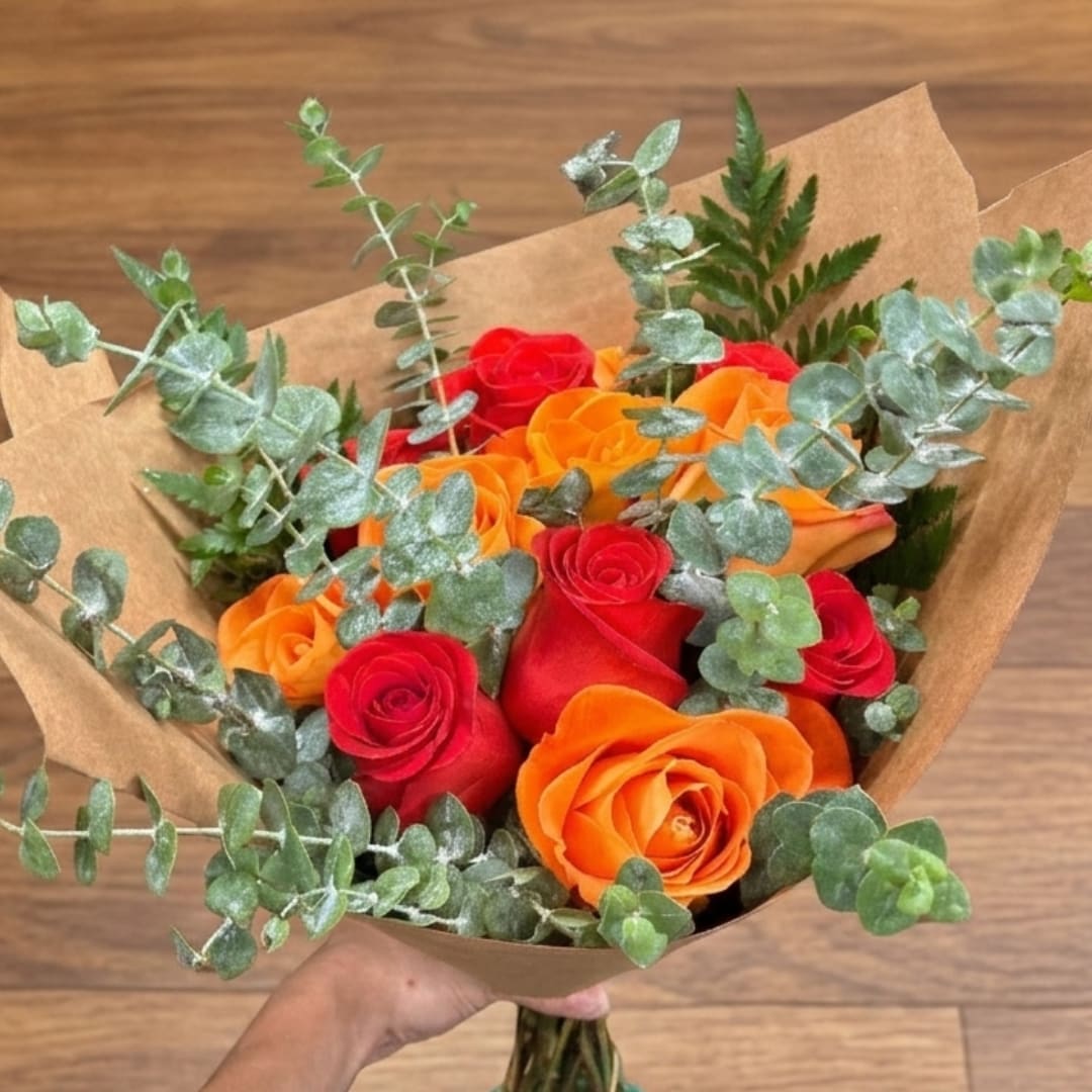Bouquet of red and orange roses wrapped in brown paper