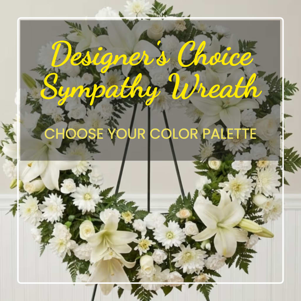 White sympathy wreath with lilies and daisies on a stand