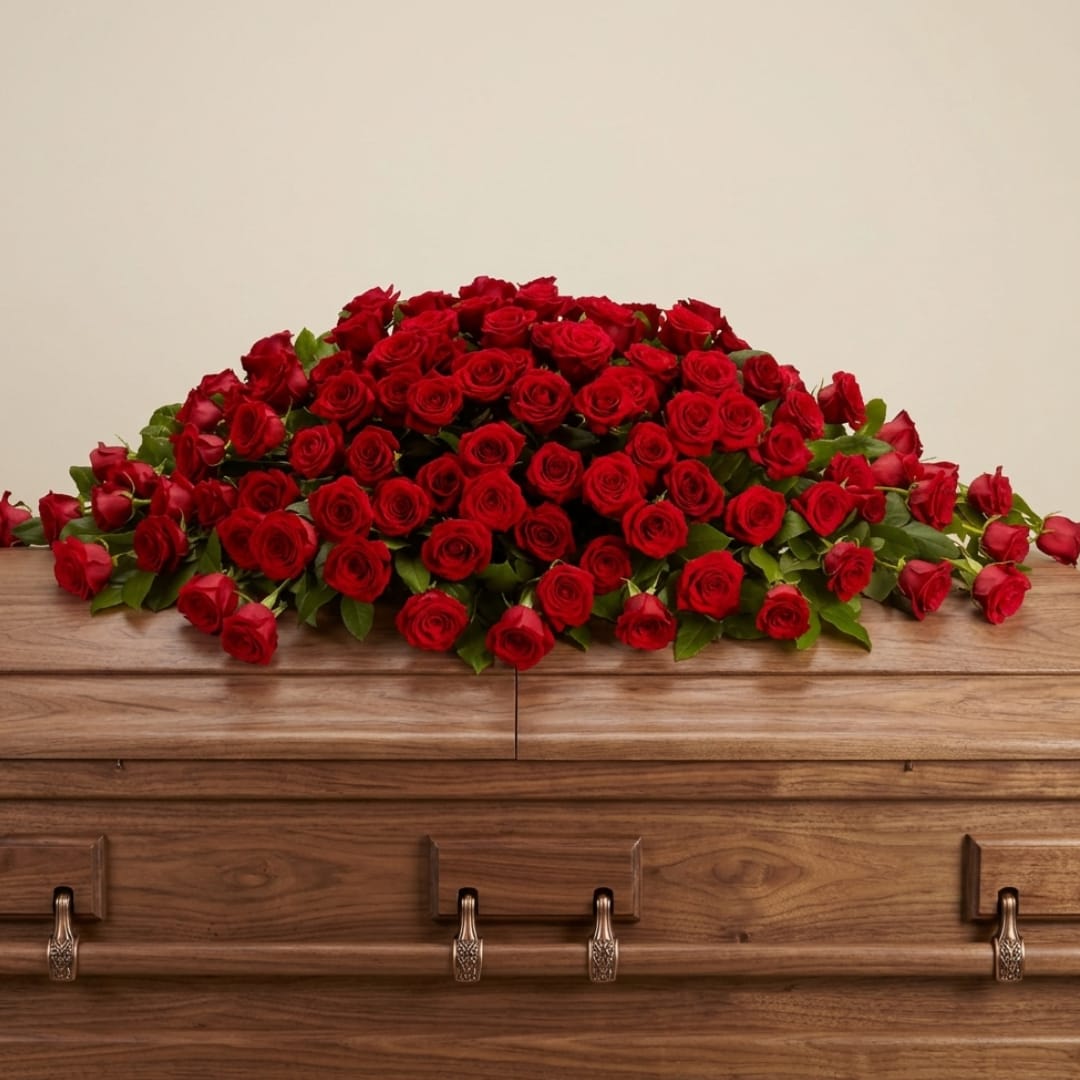 Large arrangement of red roses on a wooden casket