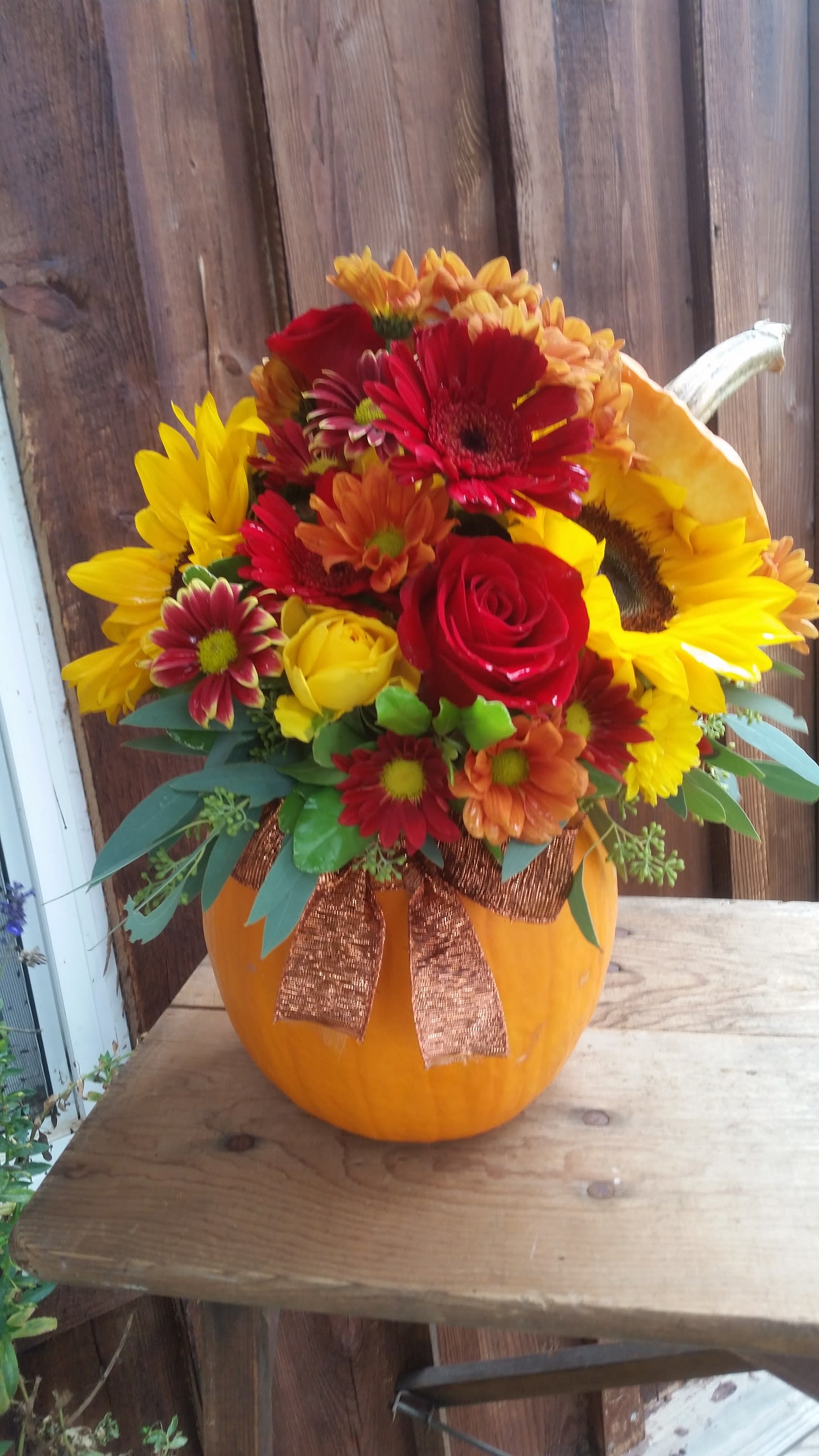 Pumpkin of Cheer - A freshly cut orange pumpkin filled with traditional fall flowers