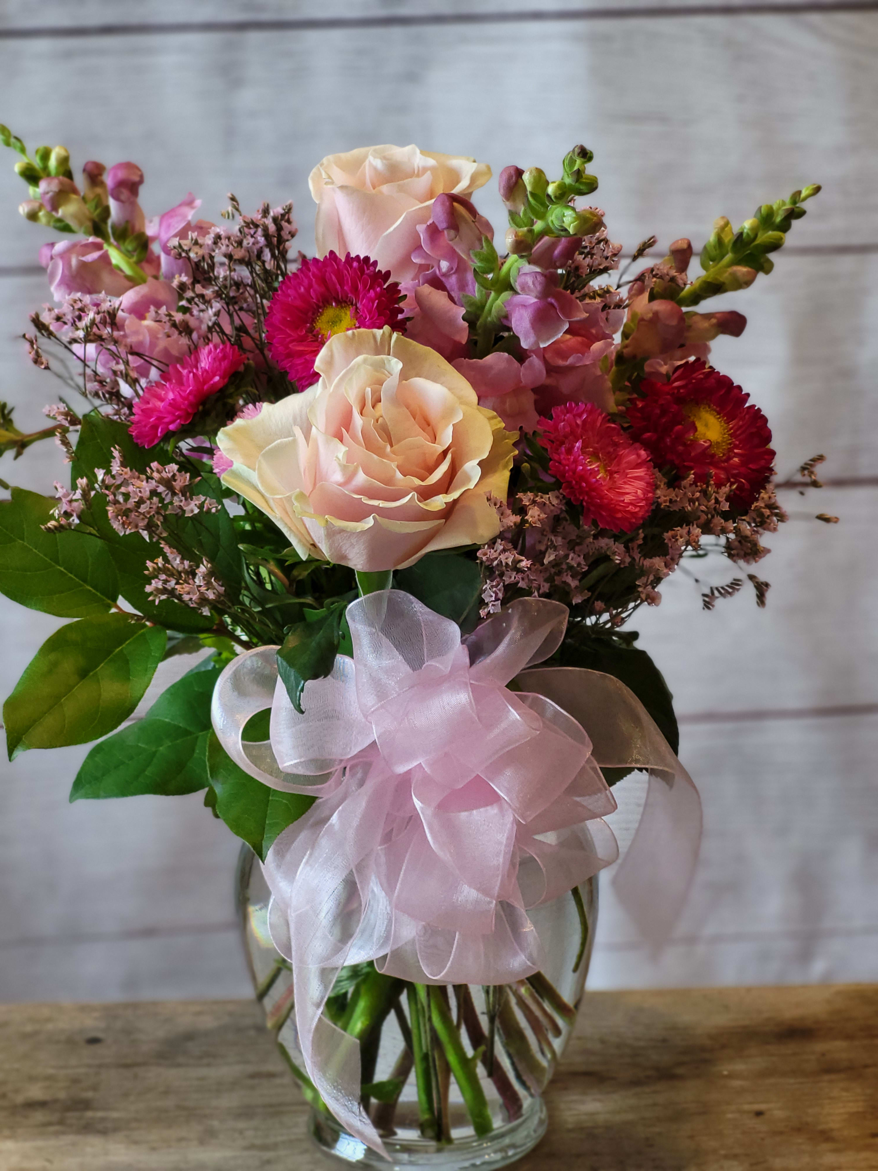 Pretty in Pink - A beautiful arrangement of roses and snapdragons, mastumoto asters, and limonium with greenery. A perfect way to send your best wishes to someone special.
