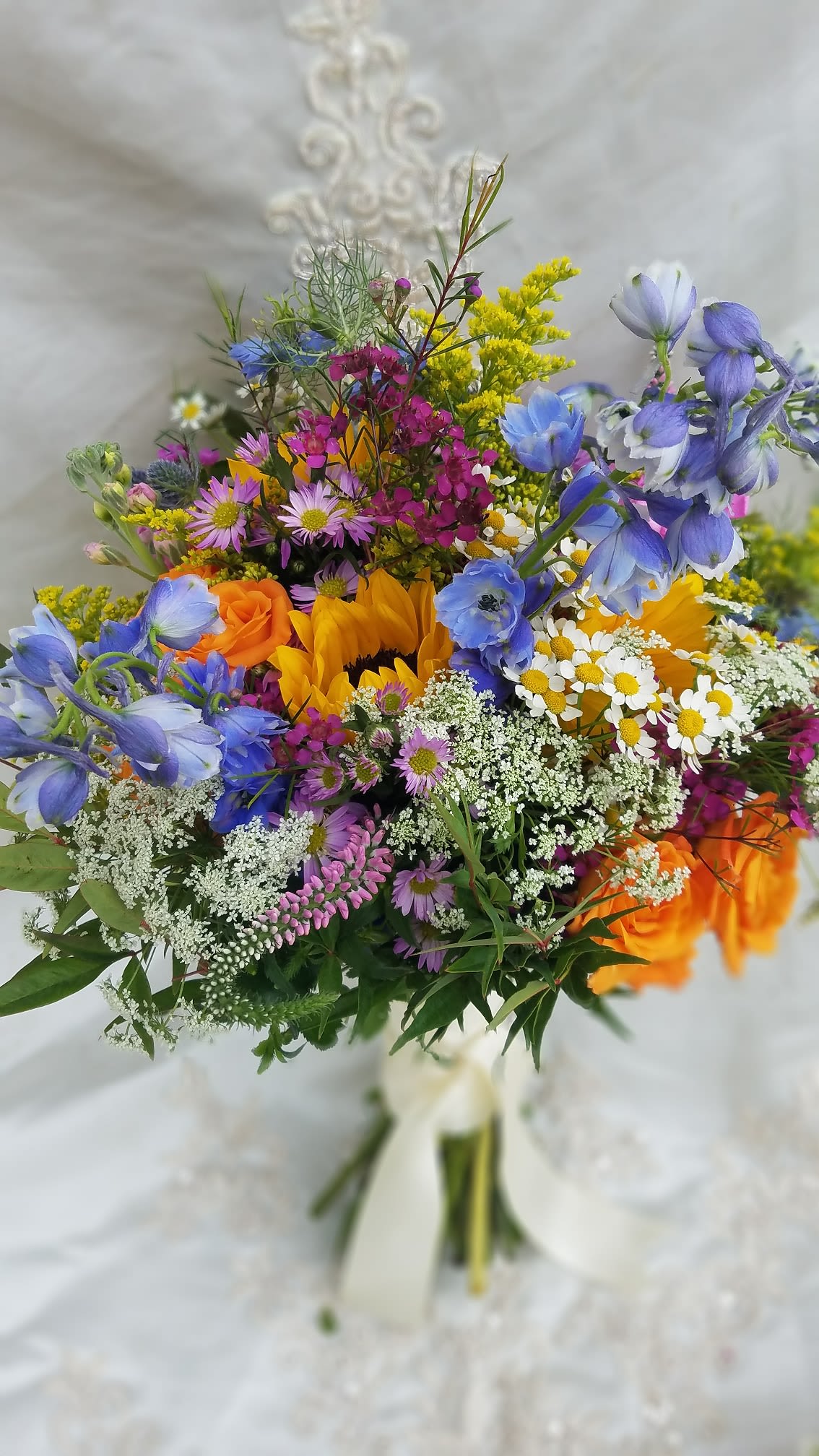 Colorful mixed bouquet with sunflowers, roses, and blue flowers