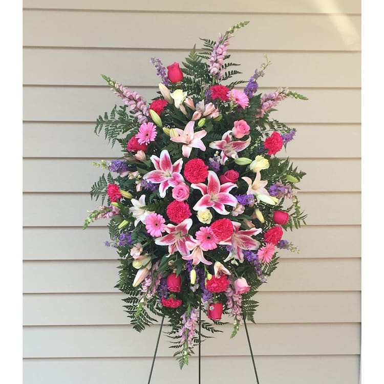Tall standing spray of pink and white flowers on an easel