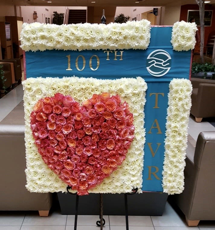 Large floral display with a red rose heart on a blue and white board