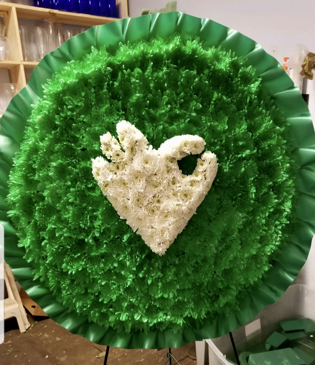 Large round floral wreath with white flowers on a green background