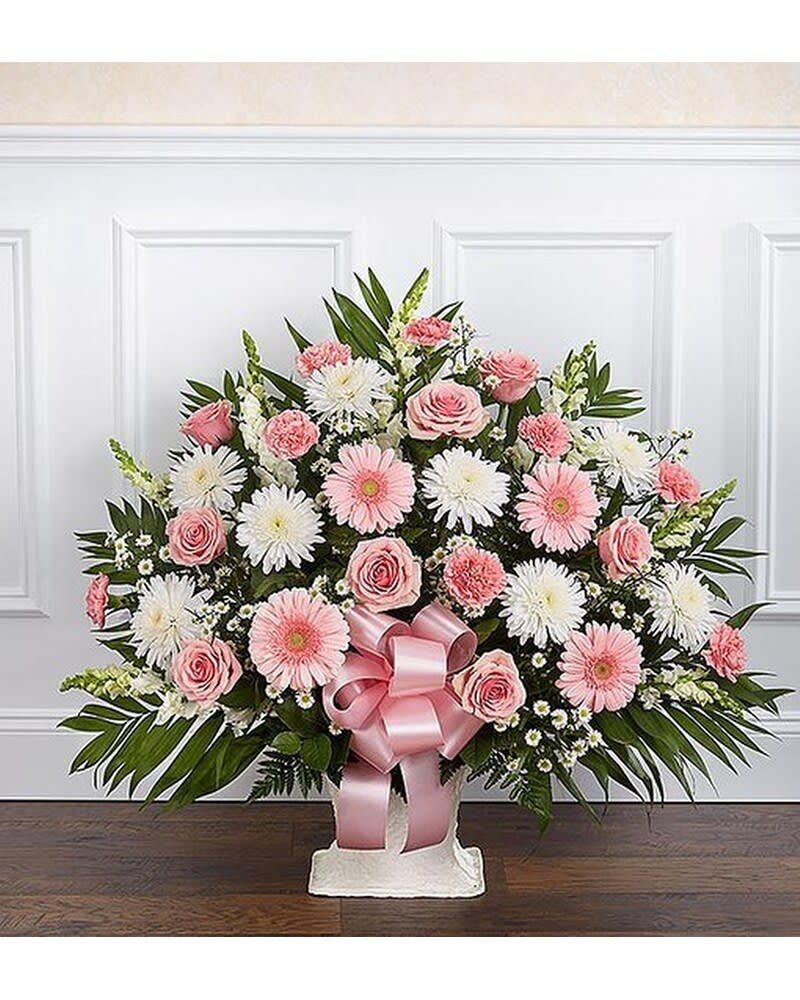 Pink and white floral spray with a pink ribbon on a stand
