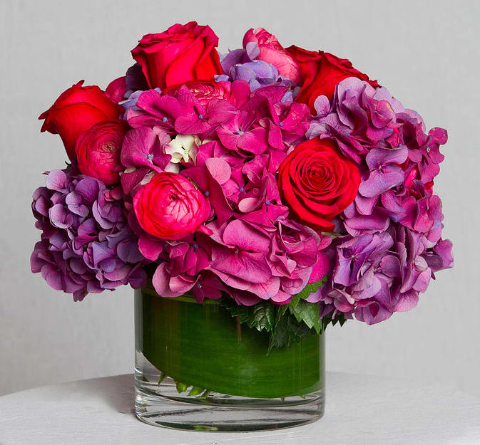 Pink and purple flower arrangement in a clear glass vase