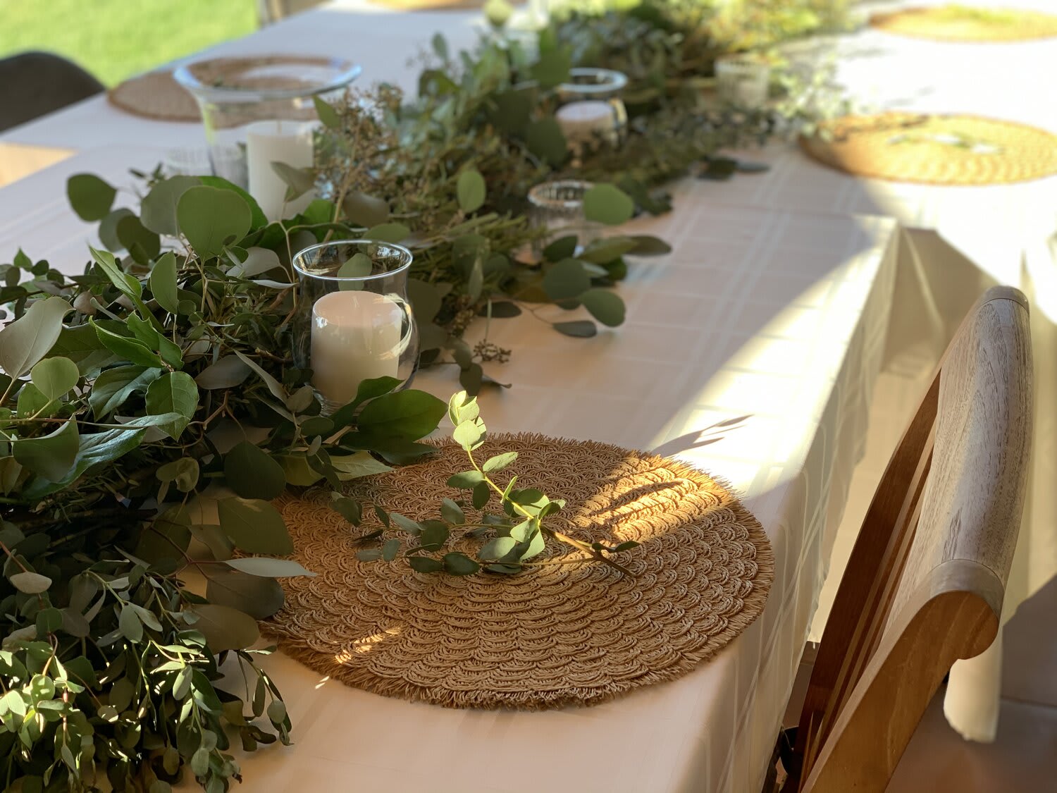 Greenery garland with glass candle holders on a white table