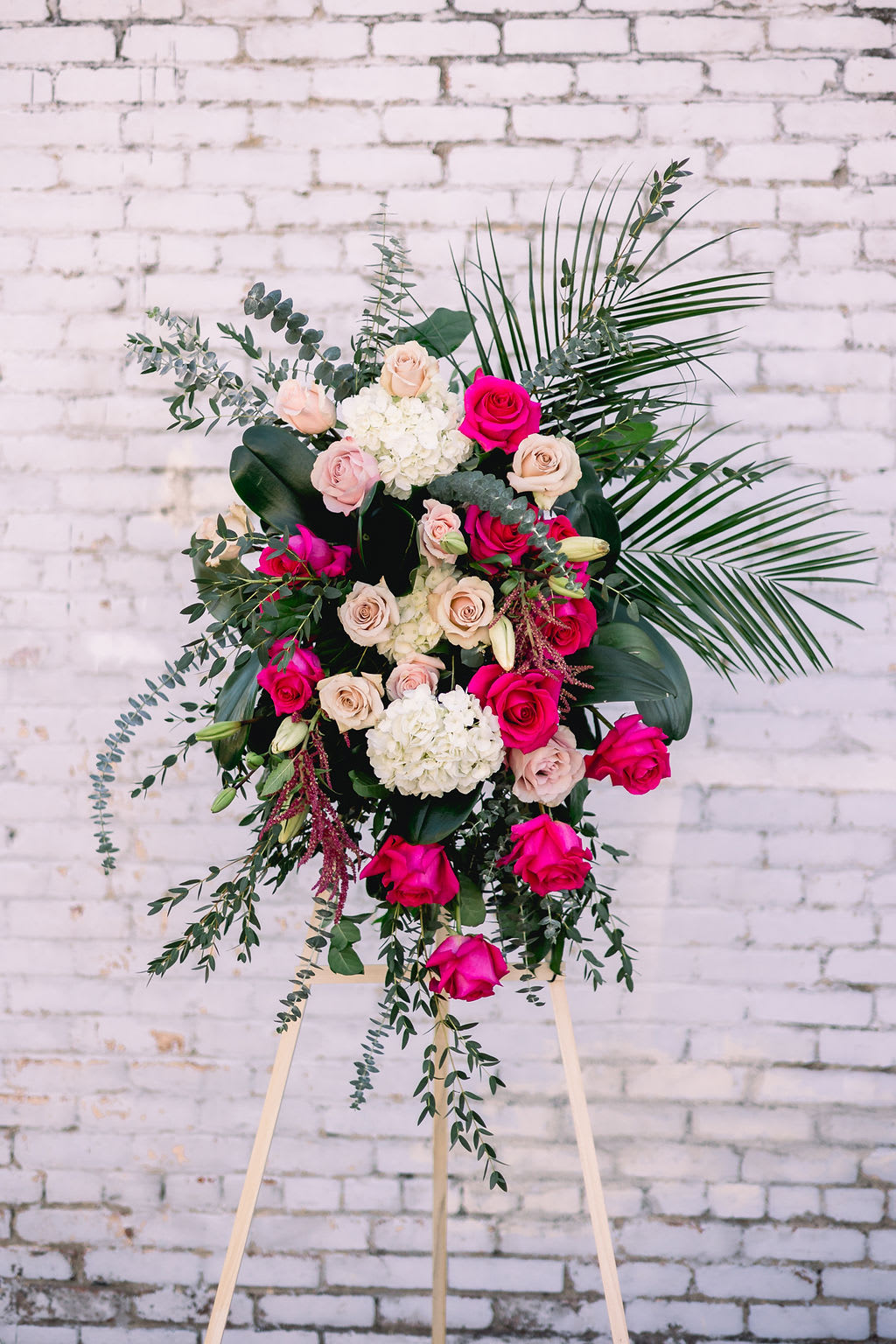 Tall floral spray with pink and cream roses on an easel