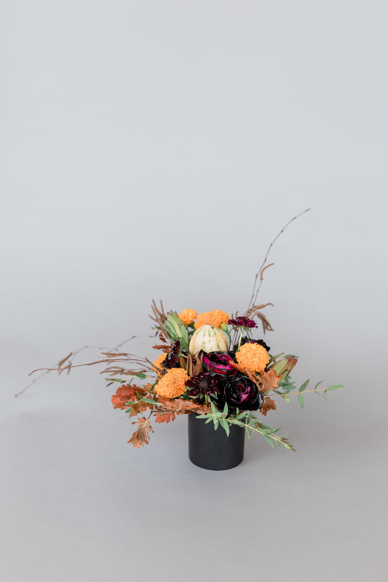 Orchid Cauldron - This stunning holiday arrangement is made up of holiday black roses, oranges, orchids, and other macabre textures!  pictured: [DELUXE]