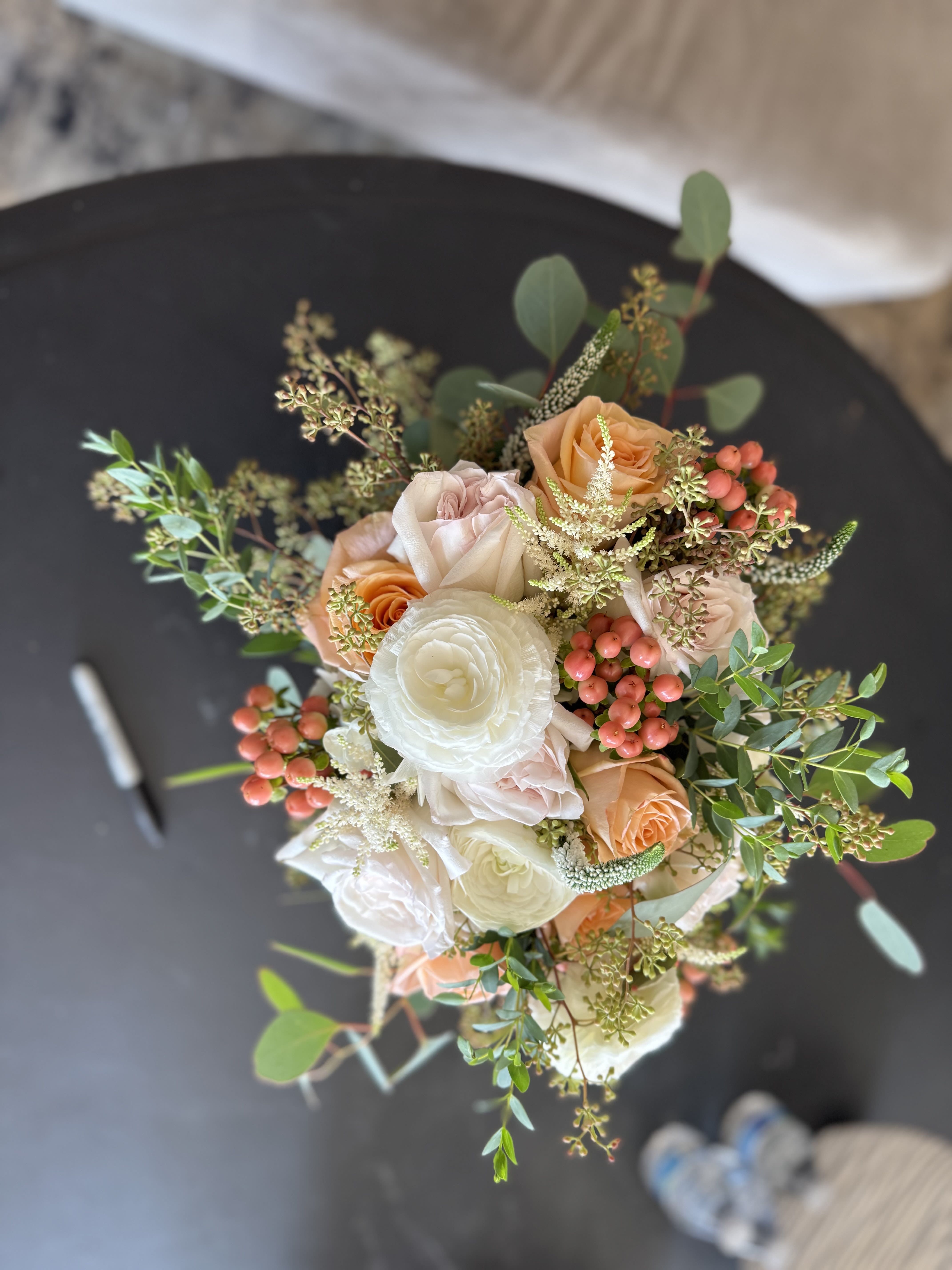 Bouquet of peach and white roses with berries and greenery