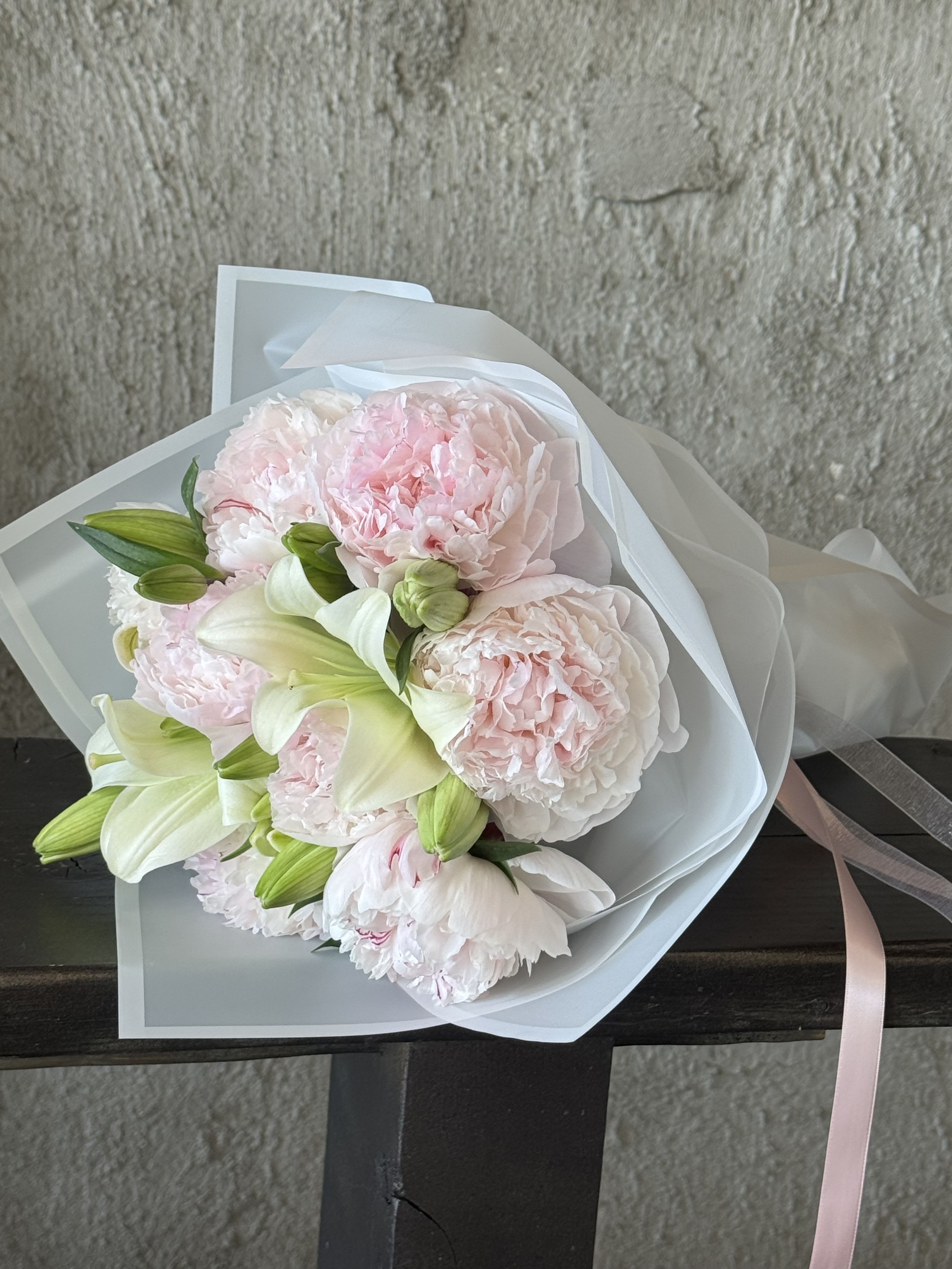 Peony Seasonal Wrap - Fresh peony wrapped bouquet. Can be mixed with other textures and greens. Be sure to specify if you have any preferences!  Please be advised that peonies are off season and imported. Local peony season starts mid April and runs through early June. 