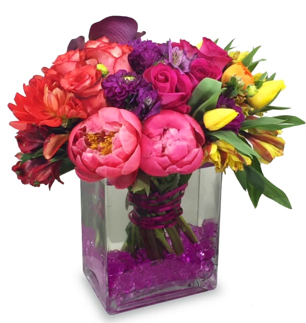 Colorful bouquet of mixed flowers in a square glass vase