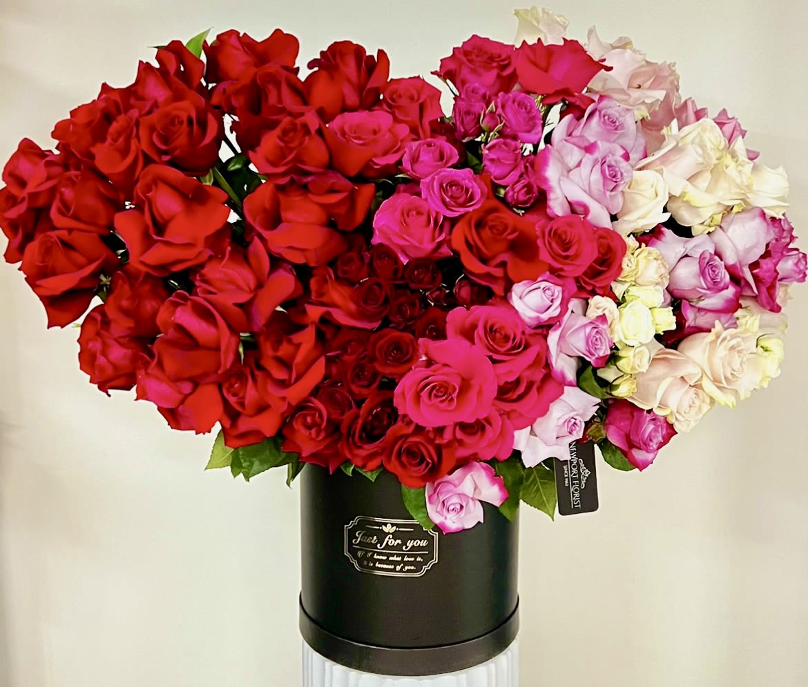 Large bouquet of red, pink, and white roses in a black hatbox