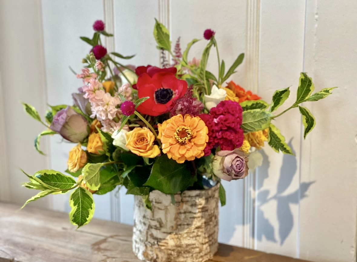 Colorful mixed flower arrangement in a birch bark vase