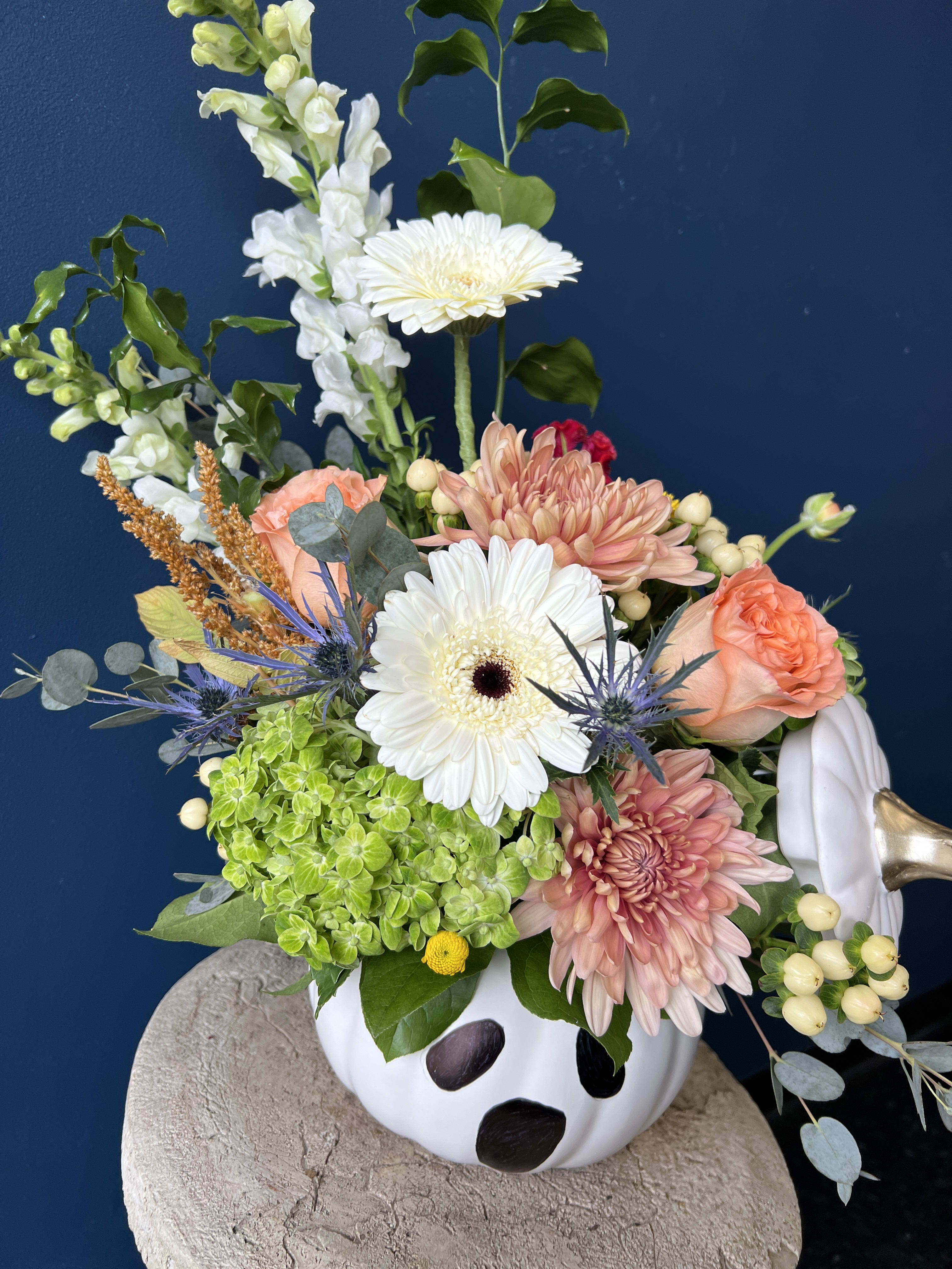 Boo - Here for a scary time, not a long time! This limited edition Boo arrangement features a mix of autumnal textures, roses, gerbera daisies, snapdragons and accented fall blooms, arranged in a spooky white ceramic pumpkin vase.