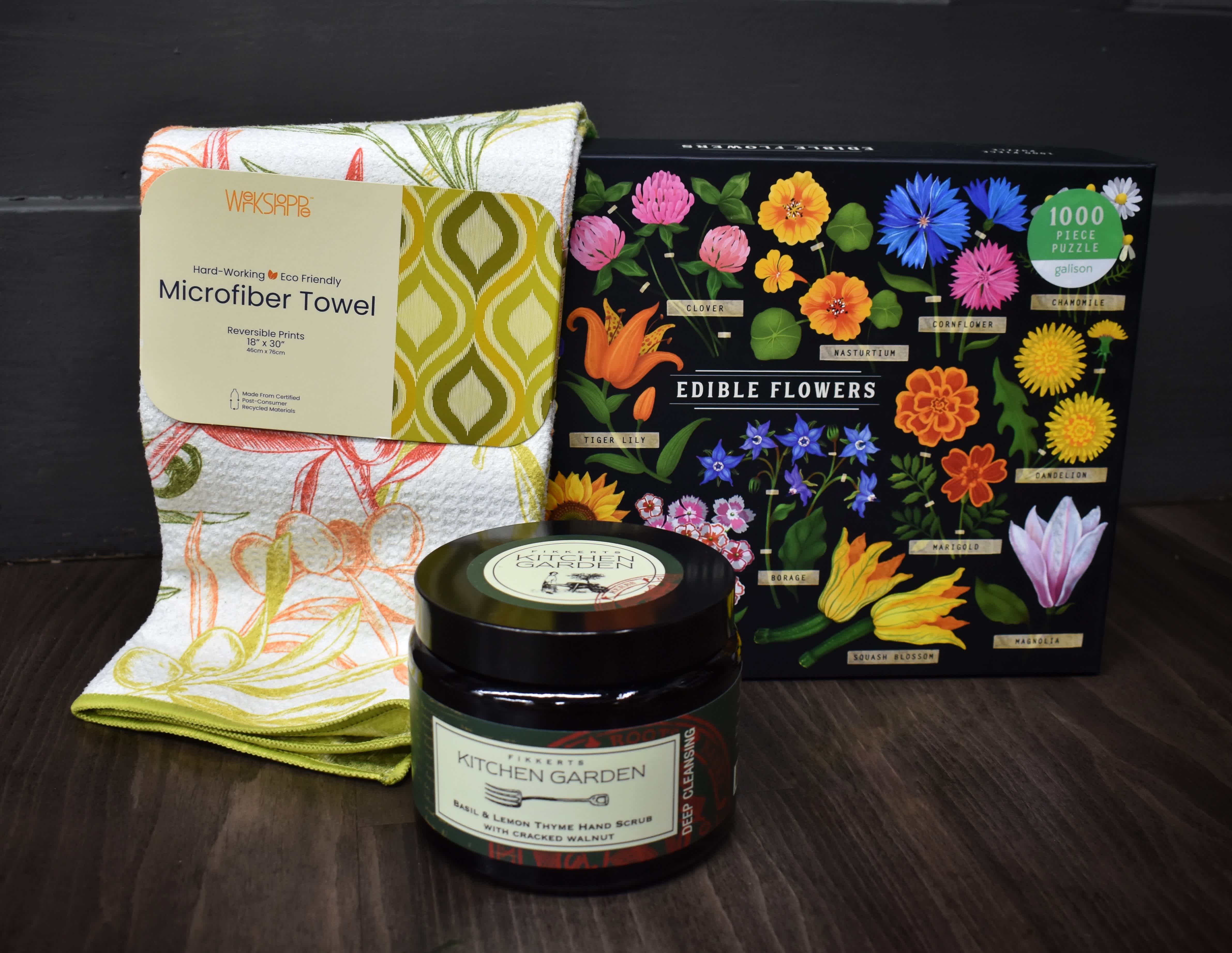 Gift set with a floral kitchen towel, edible flowers puzzle, and hand scrub jar