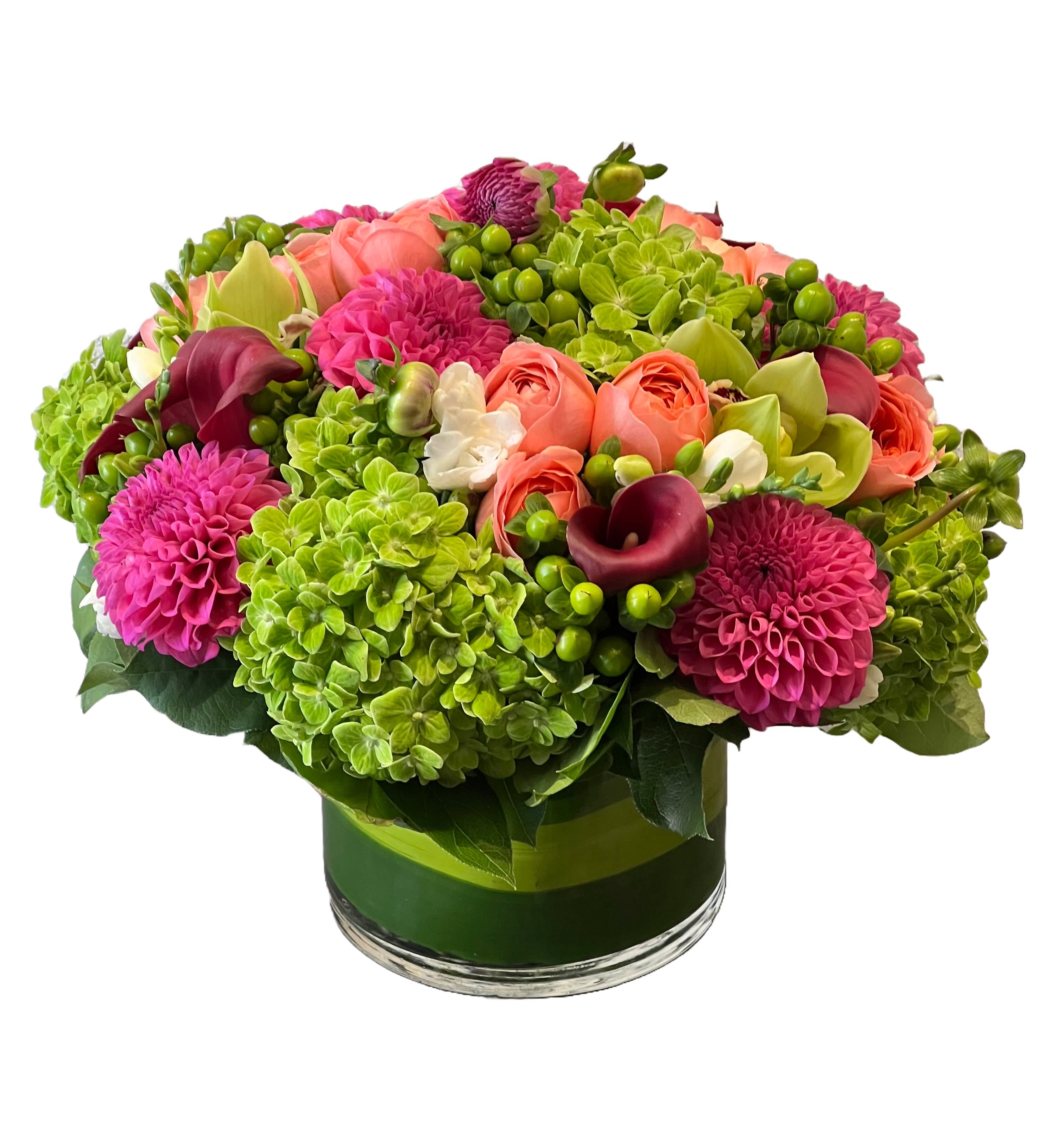 Bright mixed bouquet in a glass vase with pink, coral, and green blooms