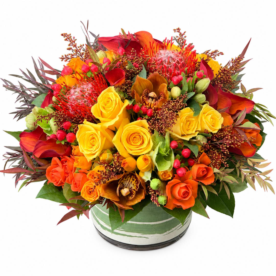 Bright mixed bouquet of yellow and orange roses in a round vase