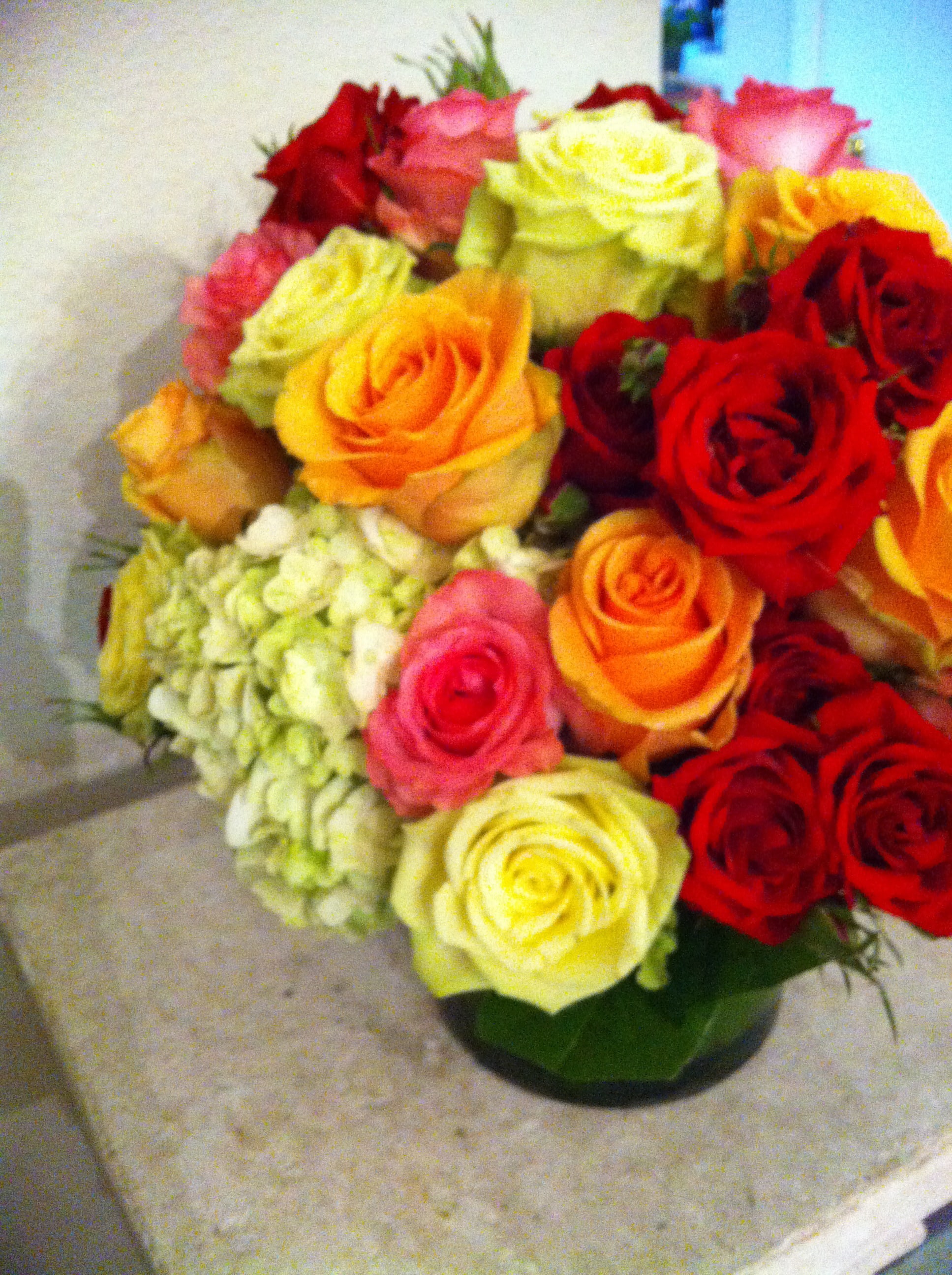 Bouquet of multicolored roses with pale hydrangea in a vase