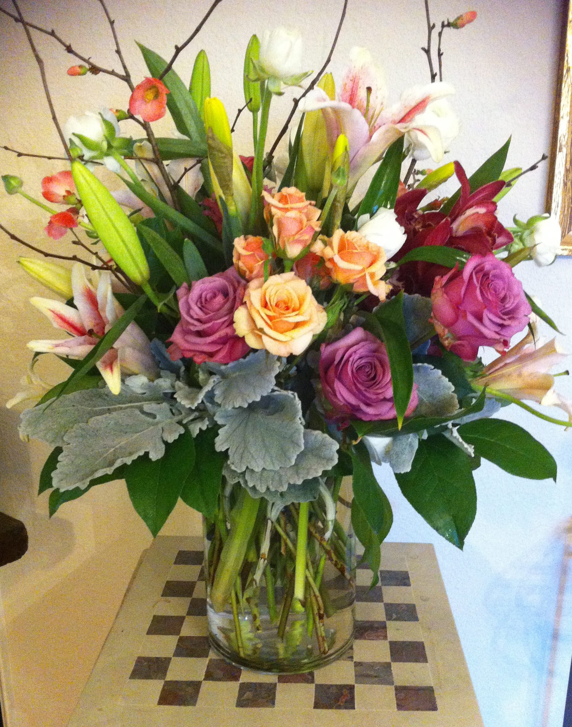 Mixed bouquet of roses and lilies in a clear glass vase