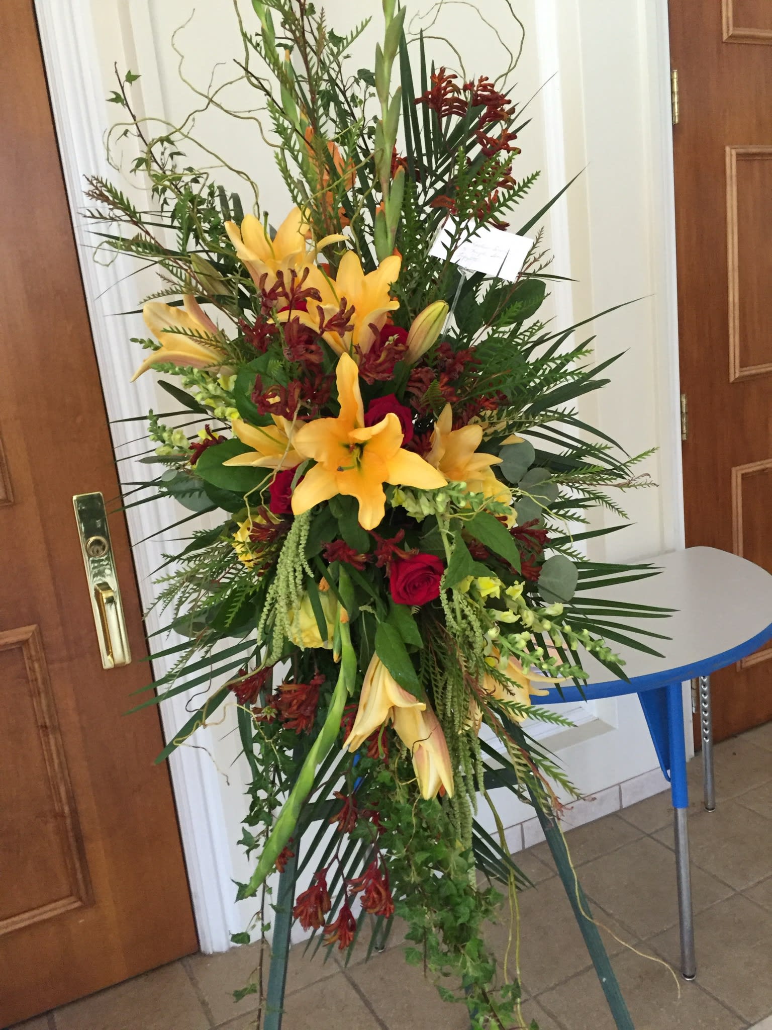 Tall floral spray with yellow lilies and red roses