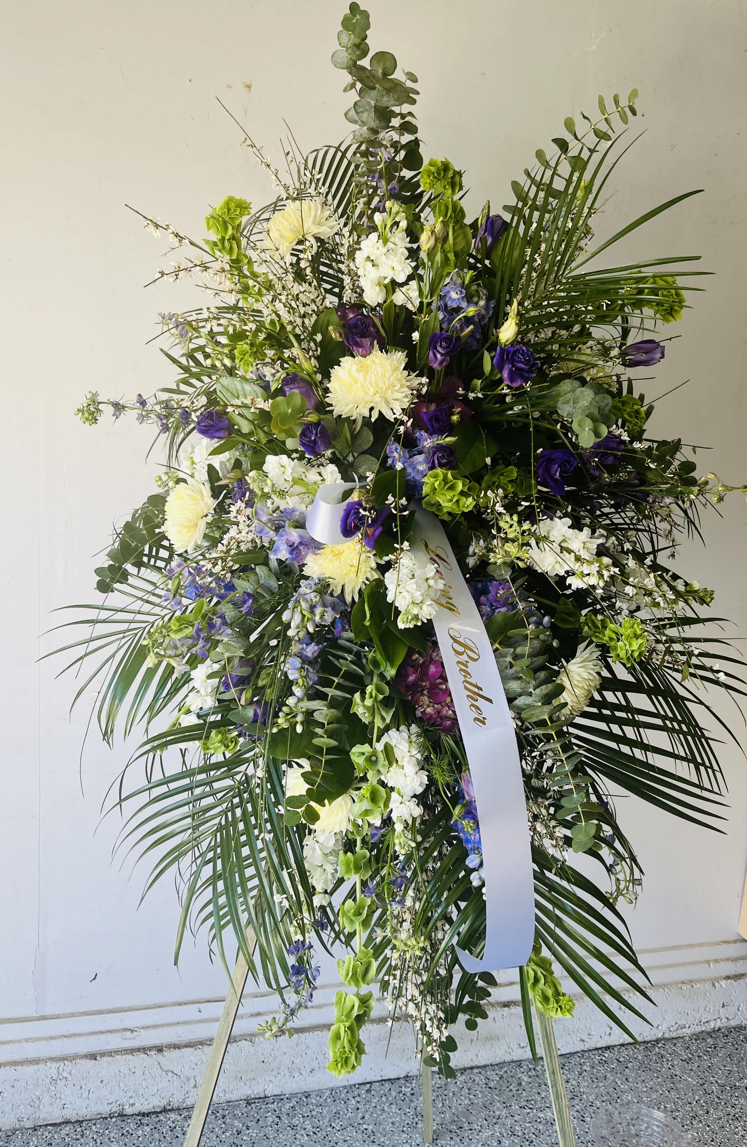 Tall standing floral spray with purple, white, and green blooms