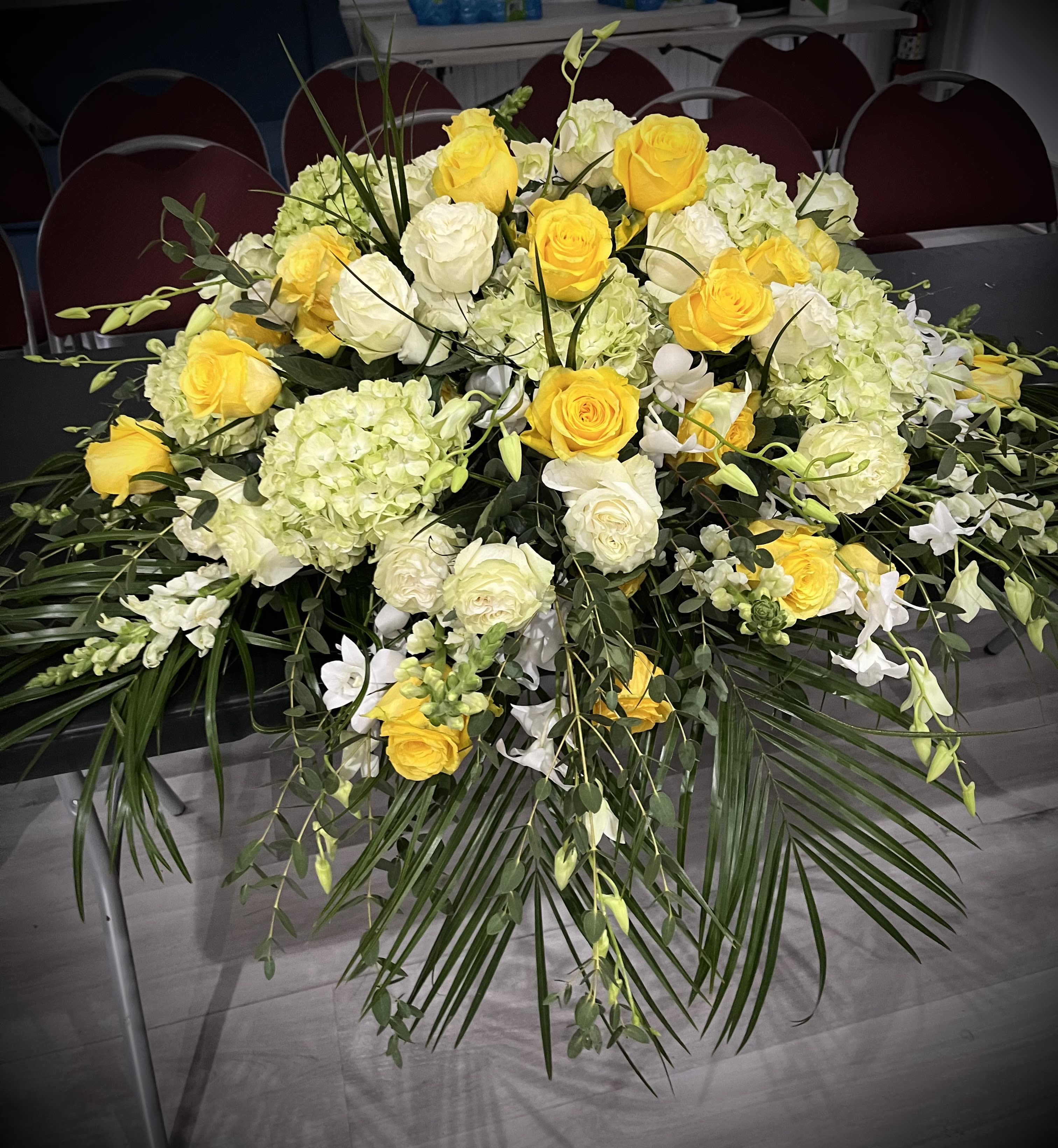 Yellow and white rose arrangement with hydrangeas and greenery