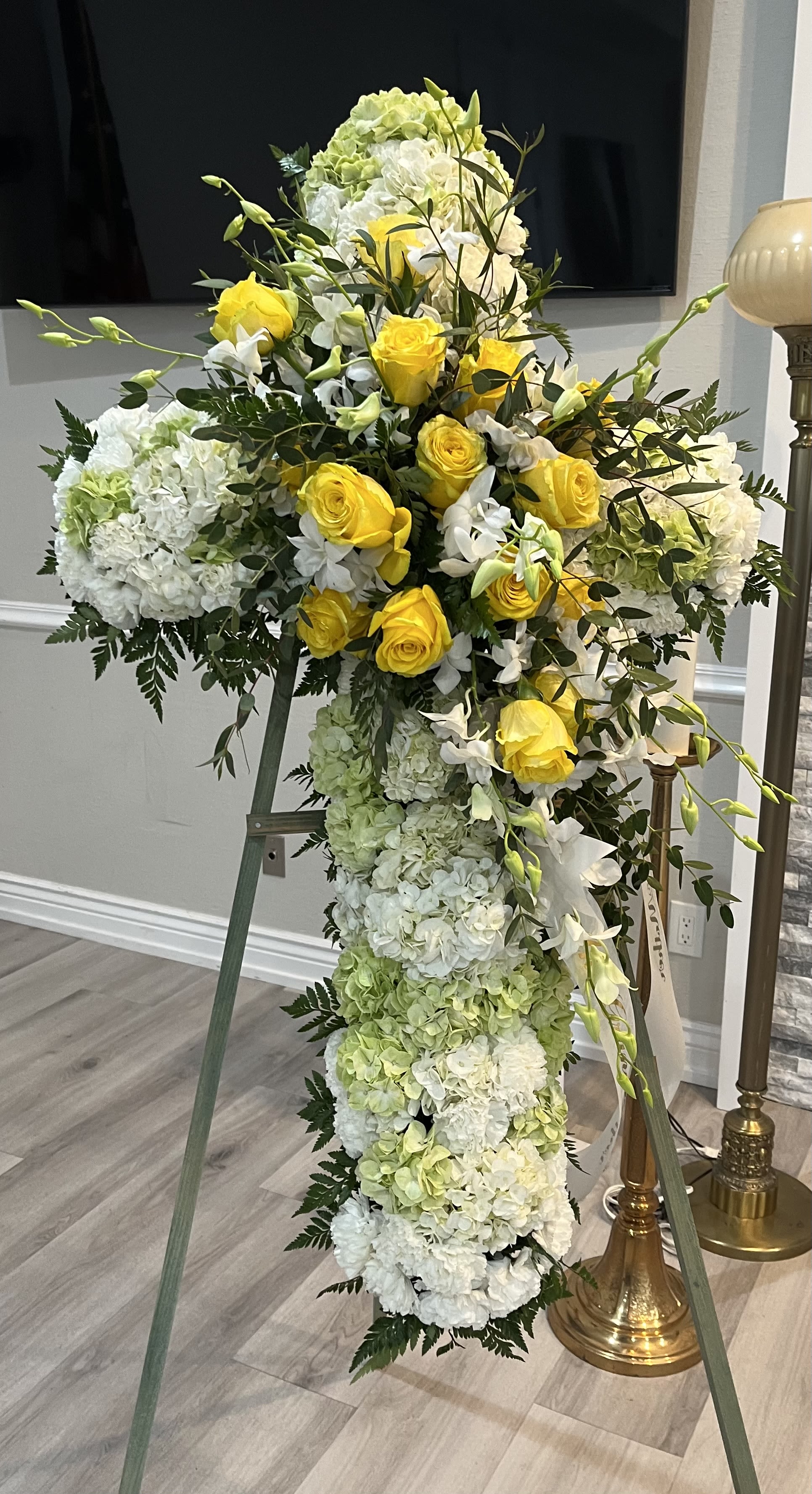 Tall standing floral cross with yellow roses and white hydrangeas