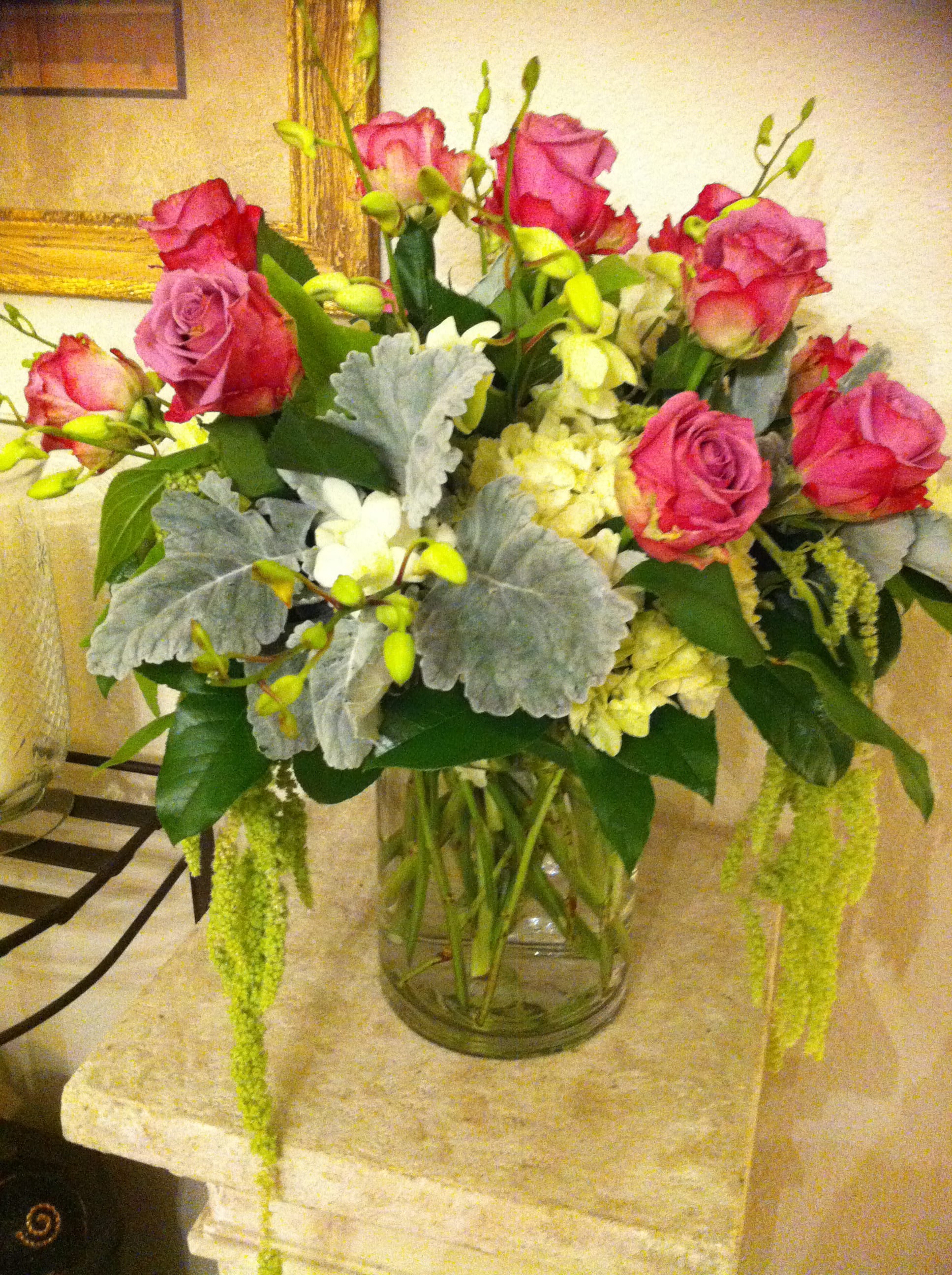 Pink roses and white flowers arranged in a clear glass vase