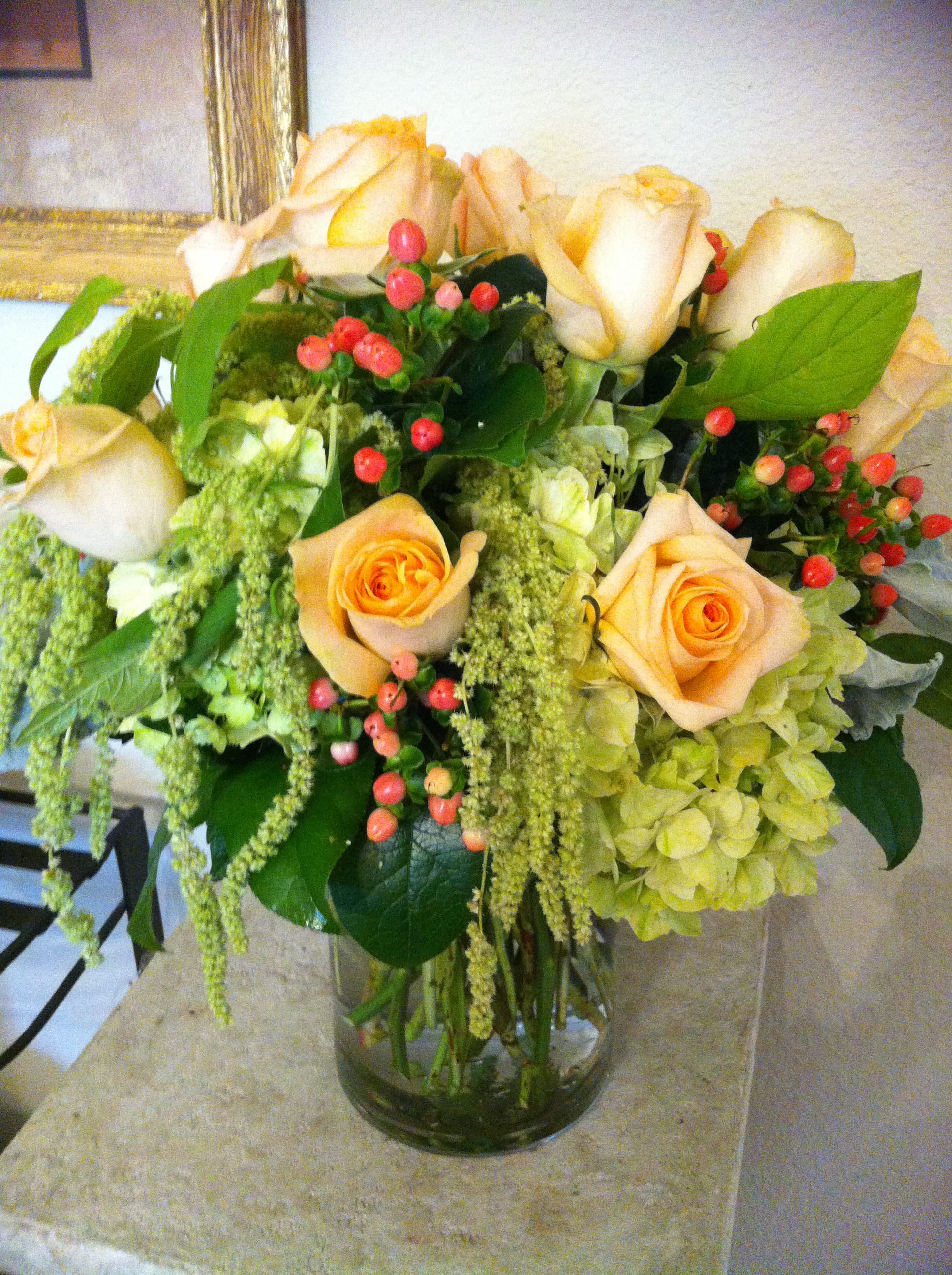 Peach roses and green hydrangeas in a glass vase