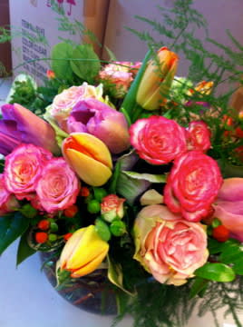 Bouquet of pink and yellow tulips with pink roses in a vase