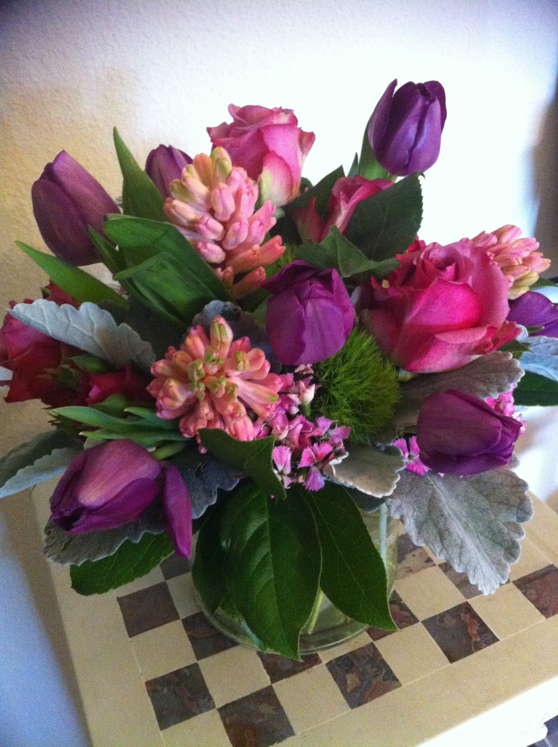 Bouquet of pink roses and purple tulips in a glass vase