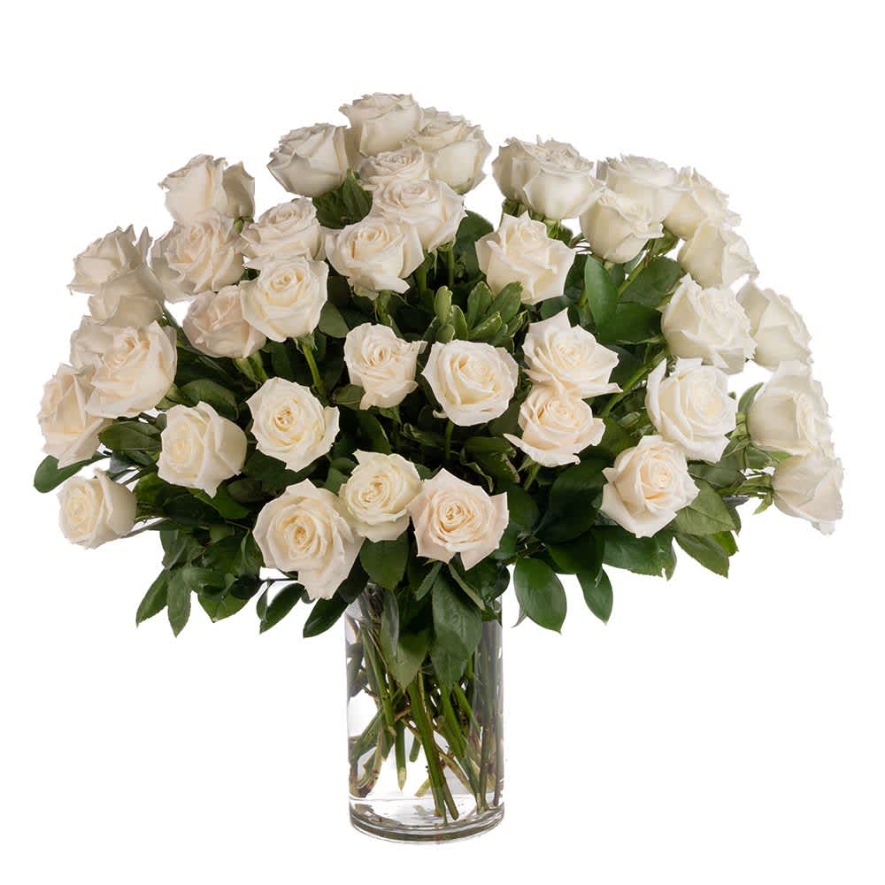 Large arrangement of white roses in a clear glass vase