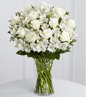The FTD Cherished Friend Bouquet - The FTD Cherished Friend Bouquet offers comfort and sympathy in the time of grief and loss. Bright white roses and Peruvian lilies are accented by lush greens and gorgeously arranged in a clear glass gathering vase to create a bouquet that will bring peace and show how much you care.