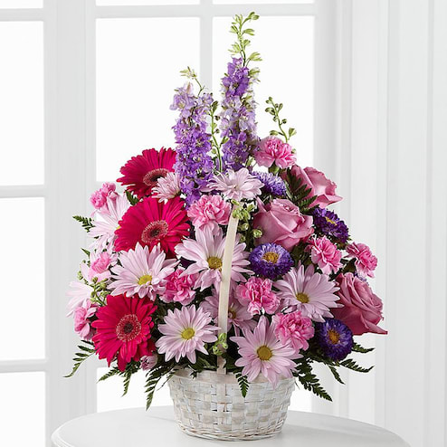  Pastel Peace Basket -  Pastel Peace Basket is a sweet and simple way to offer your condolences. Lavender roses, fuchsia gerbera daisies, lavender daisies, purple larkspur, purple matsumoto asters, pink mini carnations and lush greens are arranged to perfection in a round whitewash handled basket to create a gift that expresses your wishes for sympathy and peace.