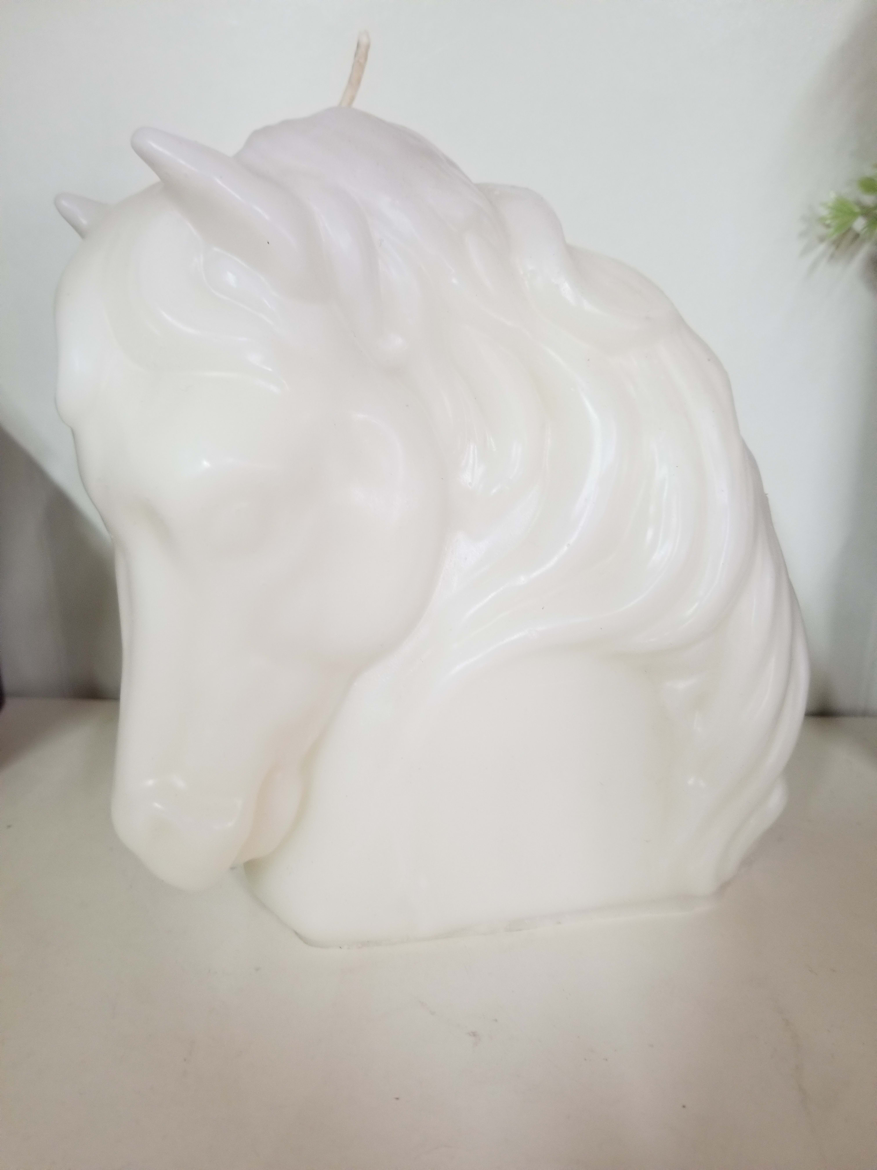 White unicorn-shaped candle with a molded mane and horn