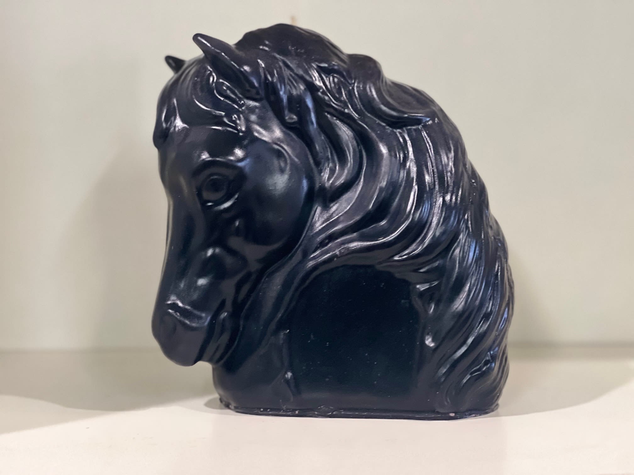 Black horse-shaped decorative object on a shelf