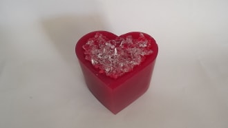 Red heart-shaped gift box filled with clear decorative crystals