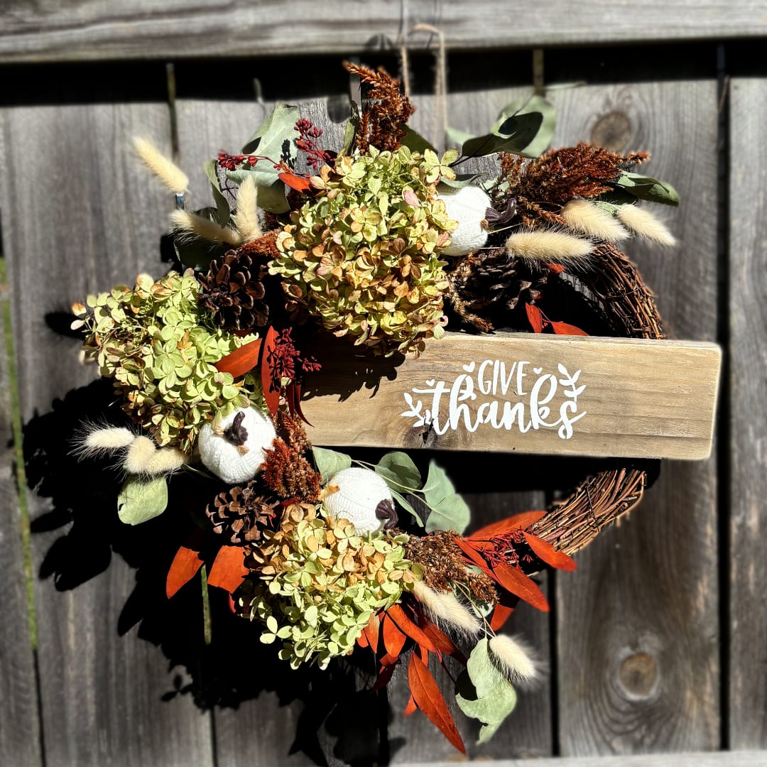 Fall wreath with dried flowers and a wooden "give thanks" sign