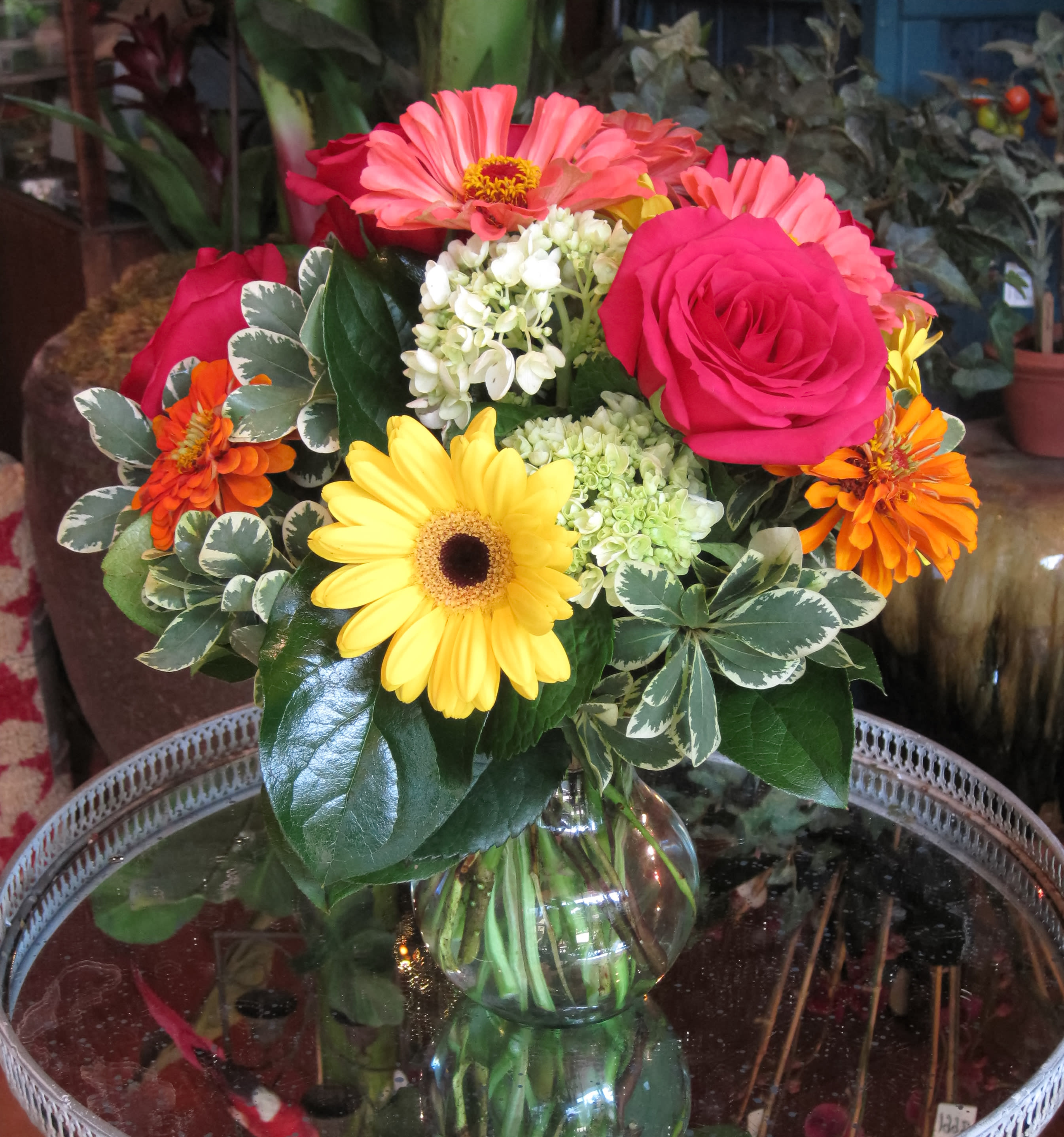 Mixed bouquet of roses, gerbera daisies, and hydrangea in a glass vase
