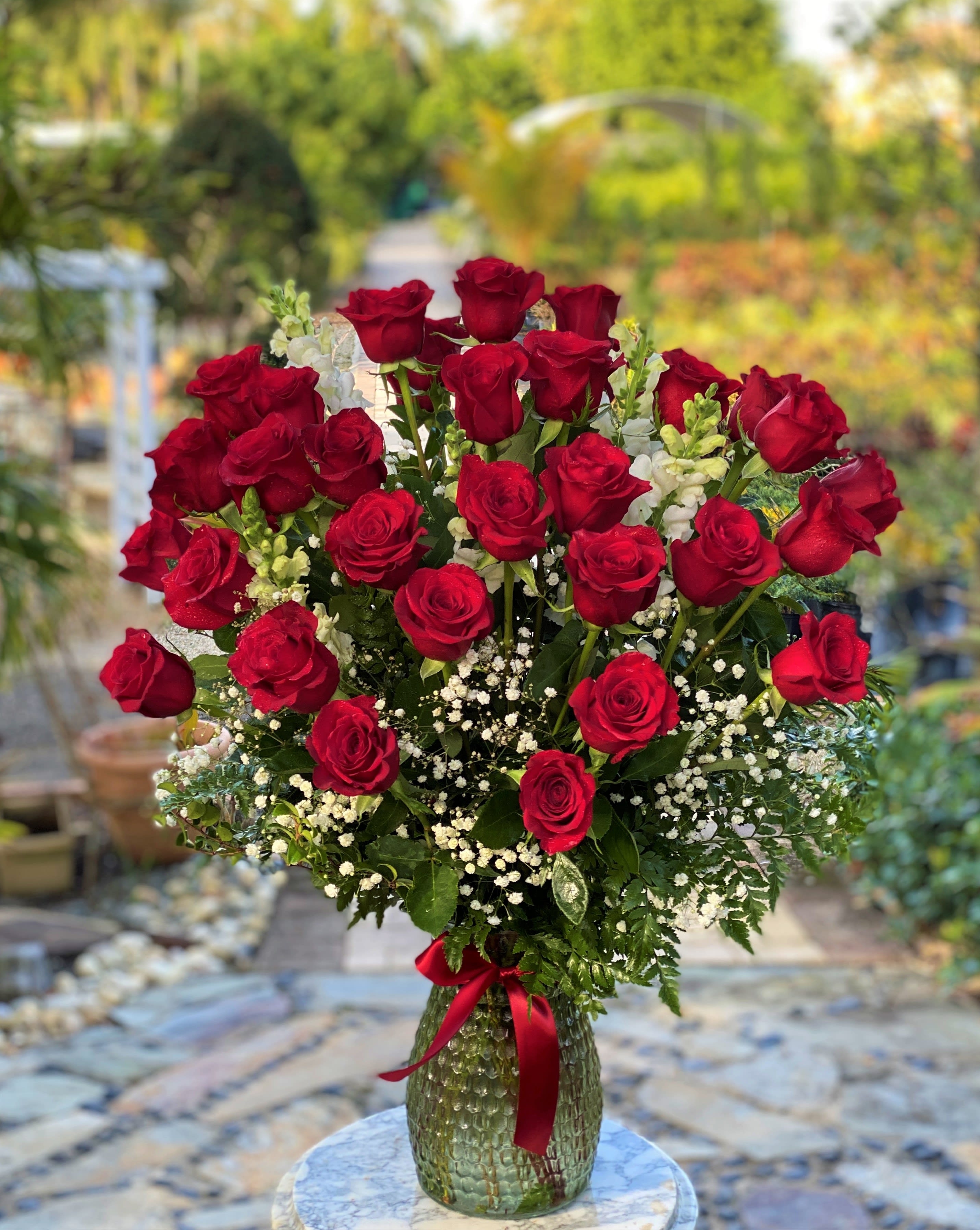 Bouquet of red roses in a glass vase with white filler flowers