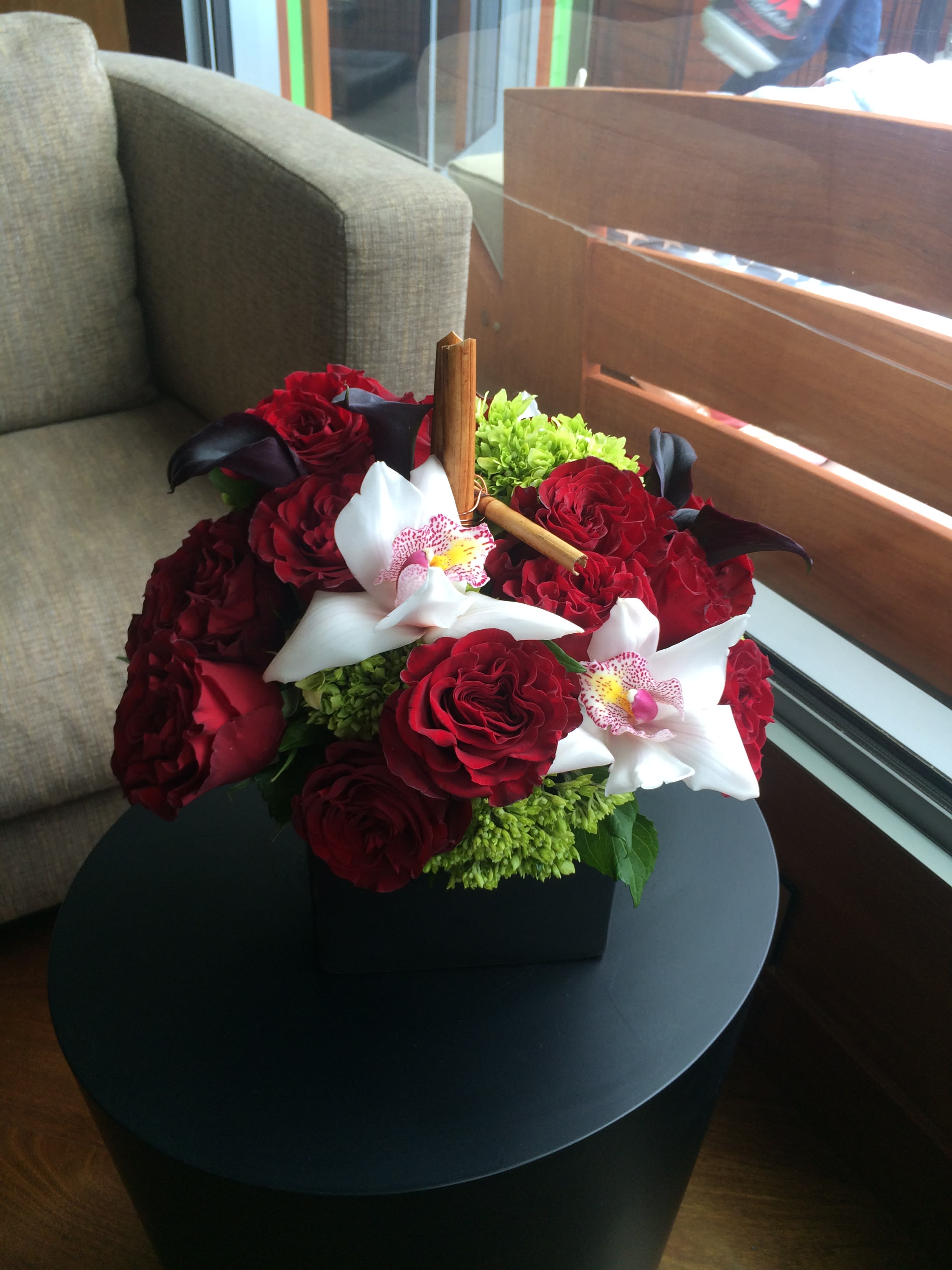 Red roses and white orchids in a black box arrangement