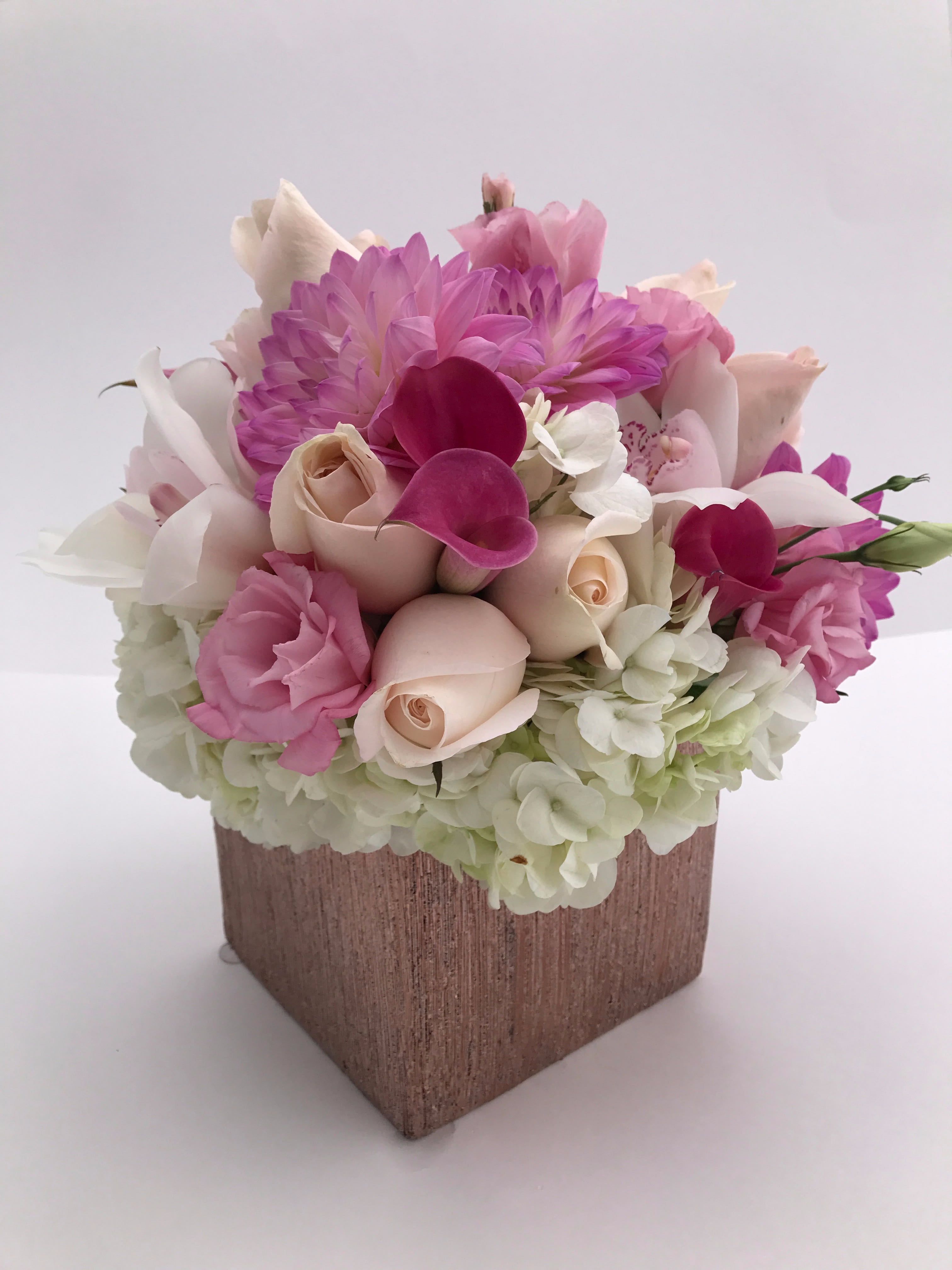 Pink and white floral arrangement in a square vase