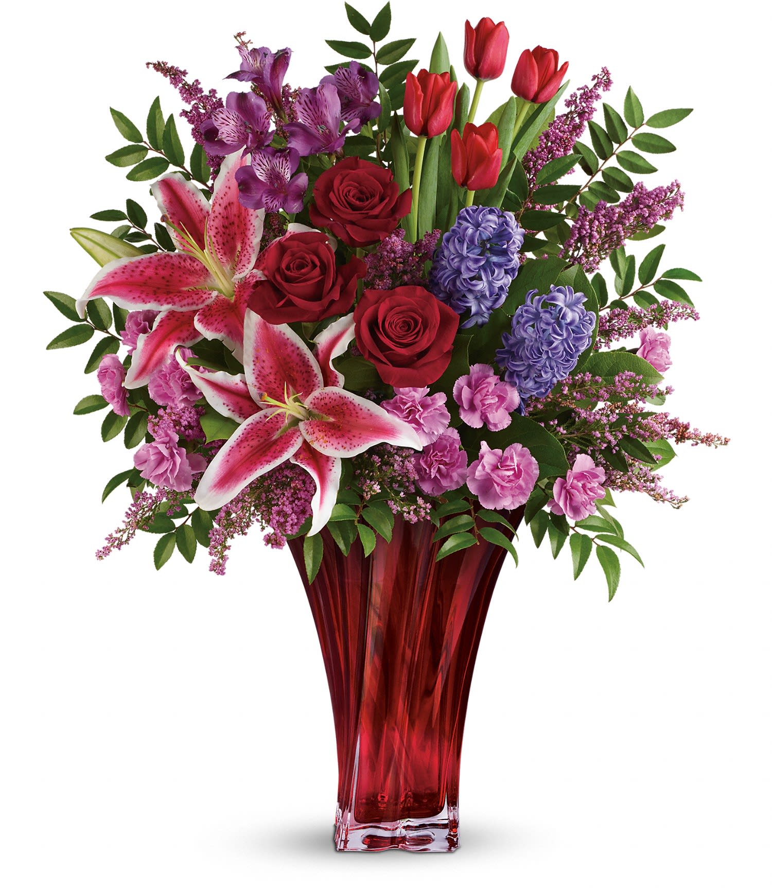 One Of A Kind Love Bouquet by Teleflora - Red roses, red tulips, pink stargazer lilies, purple alstroemeria, pink miniature carnations, and lavender hyacinth are arranged with pink heather, huckleberry and lemon leaf. Delivered in a gorgeous Love's Passion vase. Approximately 20 1/2" W x 24" H