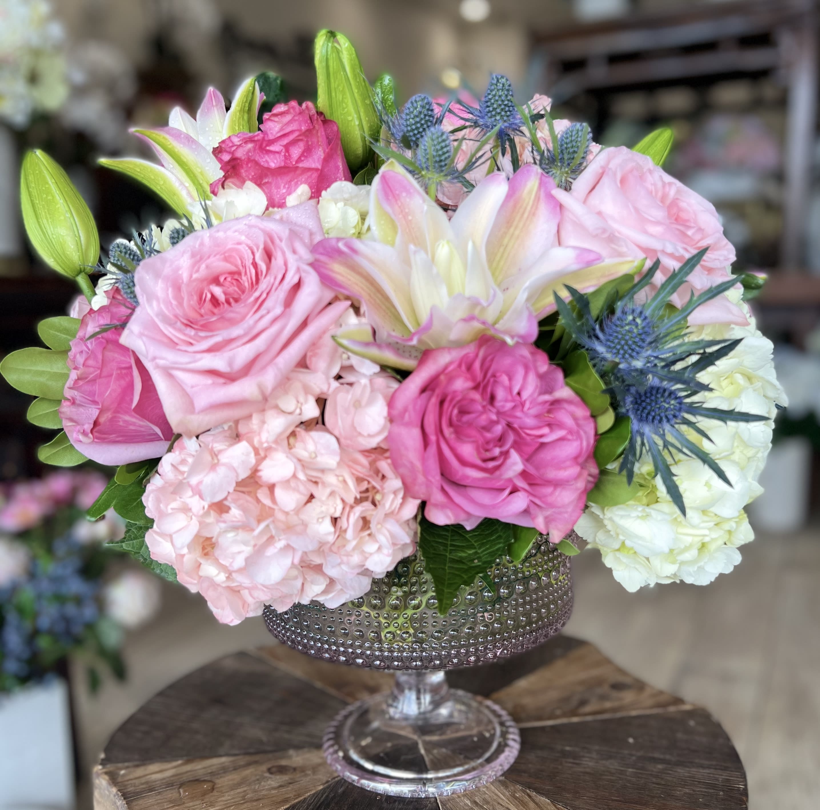 Pink and white floral arrangement in a jeweled glass vase